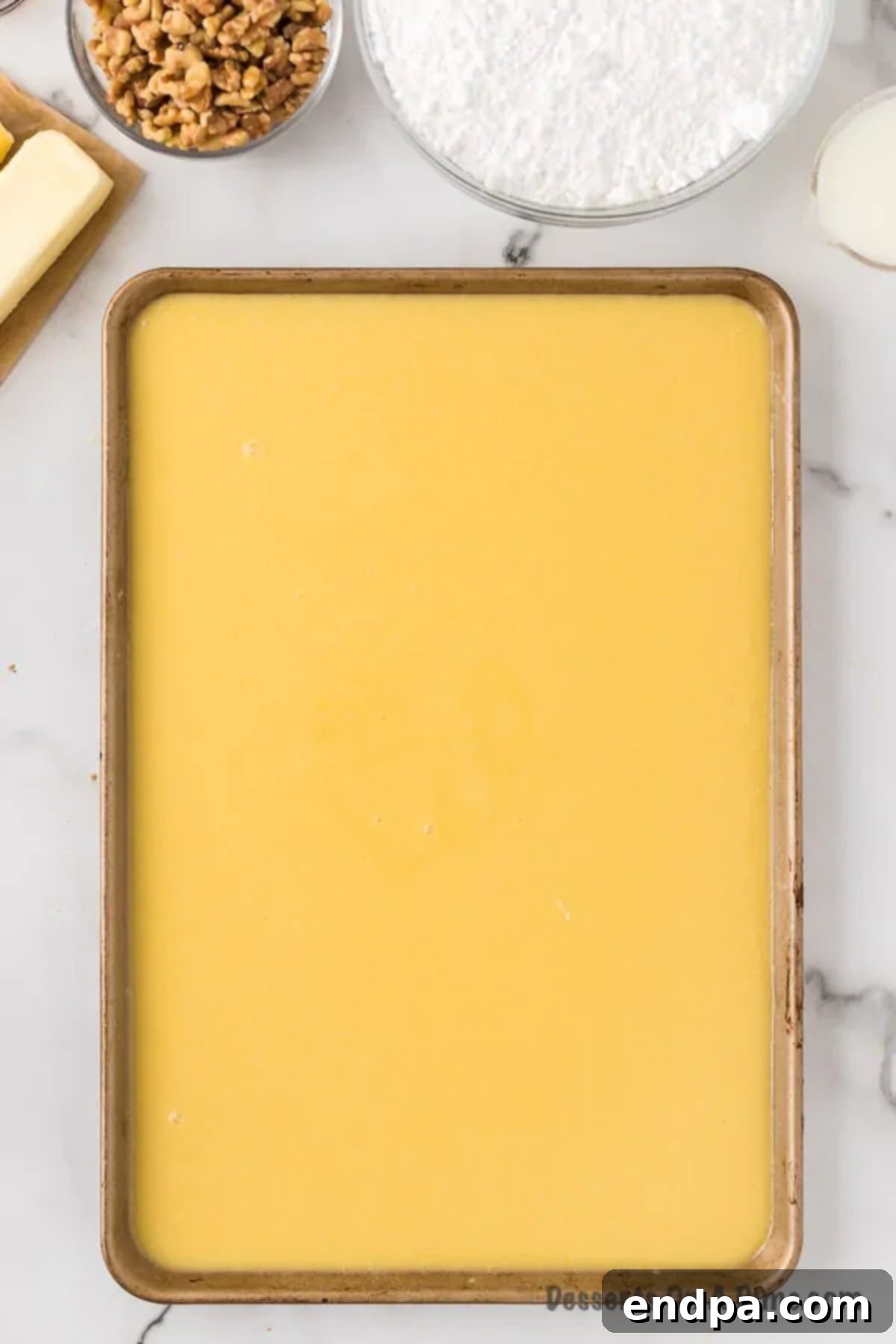 Smooth cake batter spread evenly in a prepared baking pan.