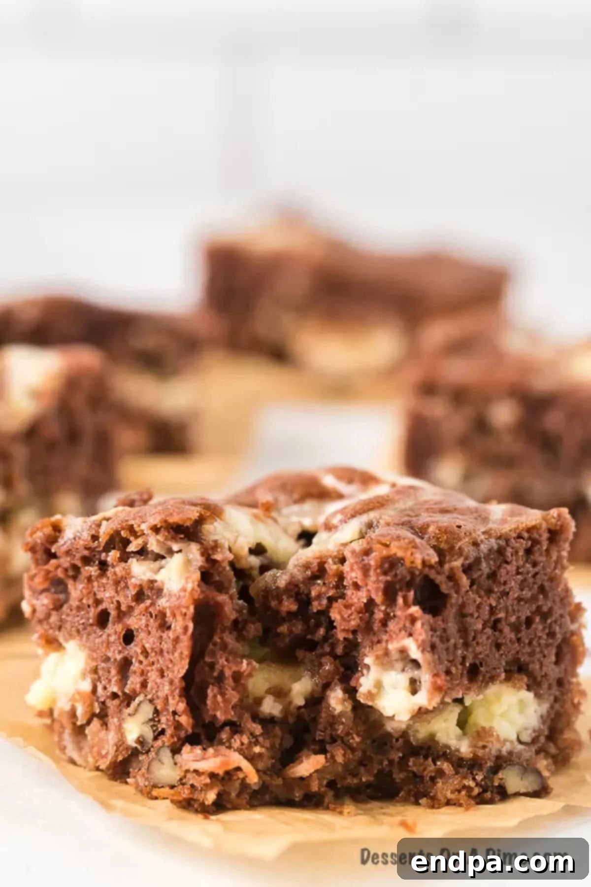 Decadent German Chocolate Cheesecake Bars 2 Slice of German Chocolate Cheesecake Bar on a plate.