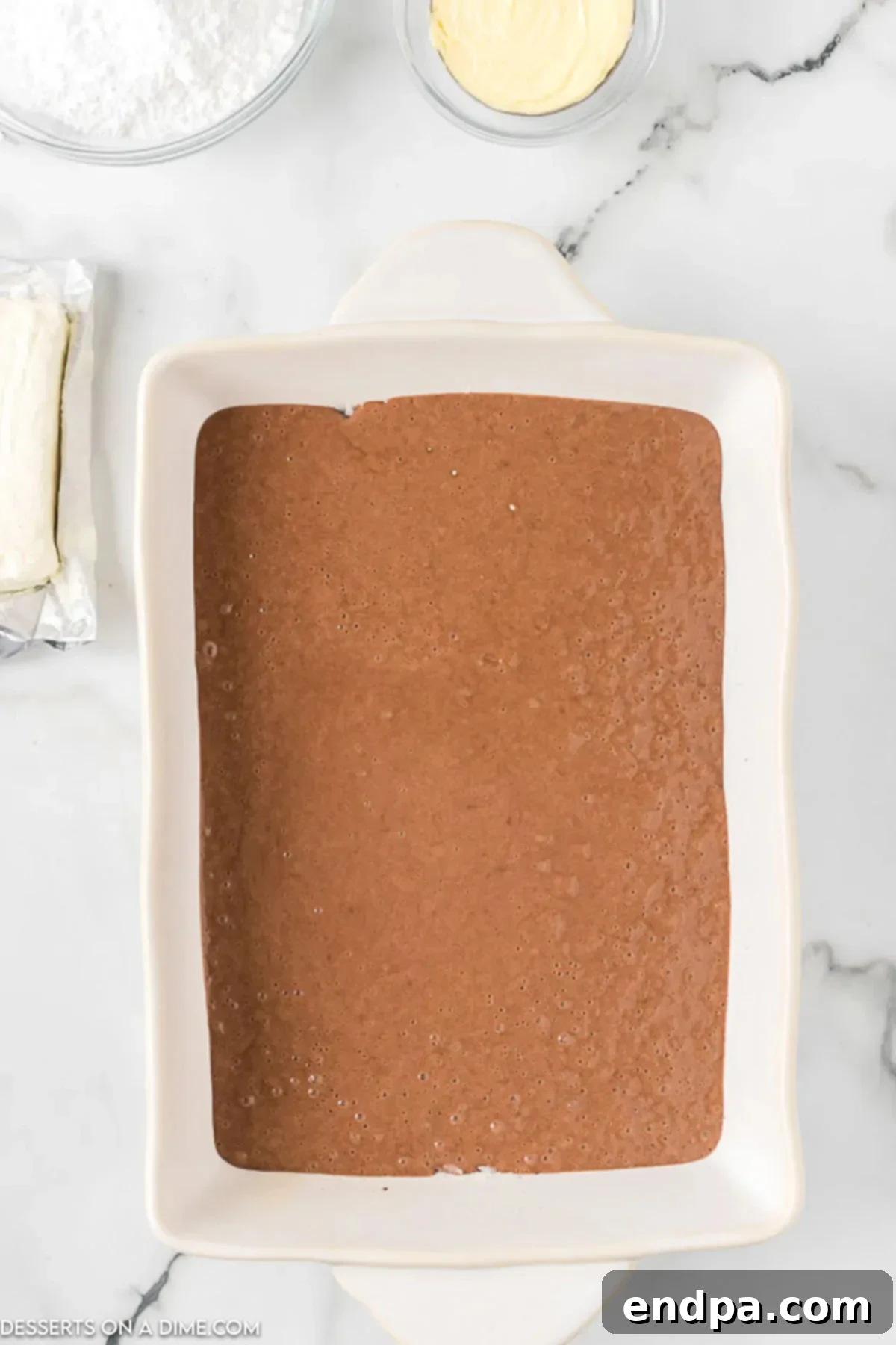 Decadent German Chocolate Cheesecake Bars 5 Cake batter spread in baking dish.