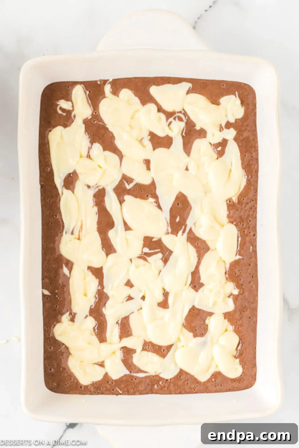 Decadent German Chocolate Cheesecake Bars 7 Cream cheese mixture spooned on top of mixture in baking dish.