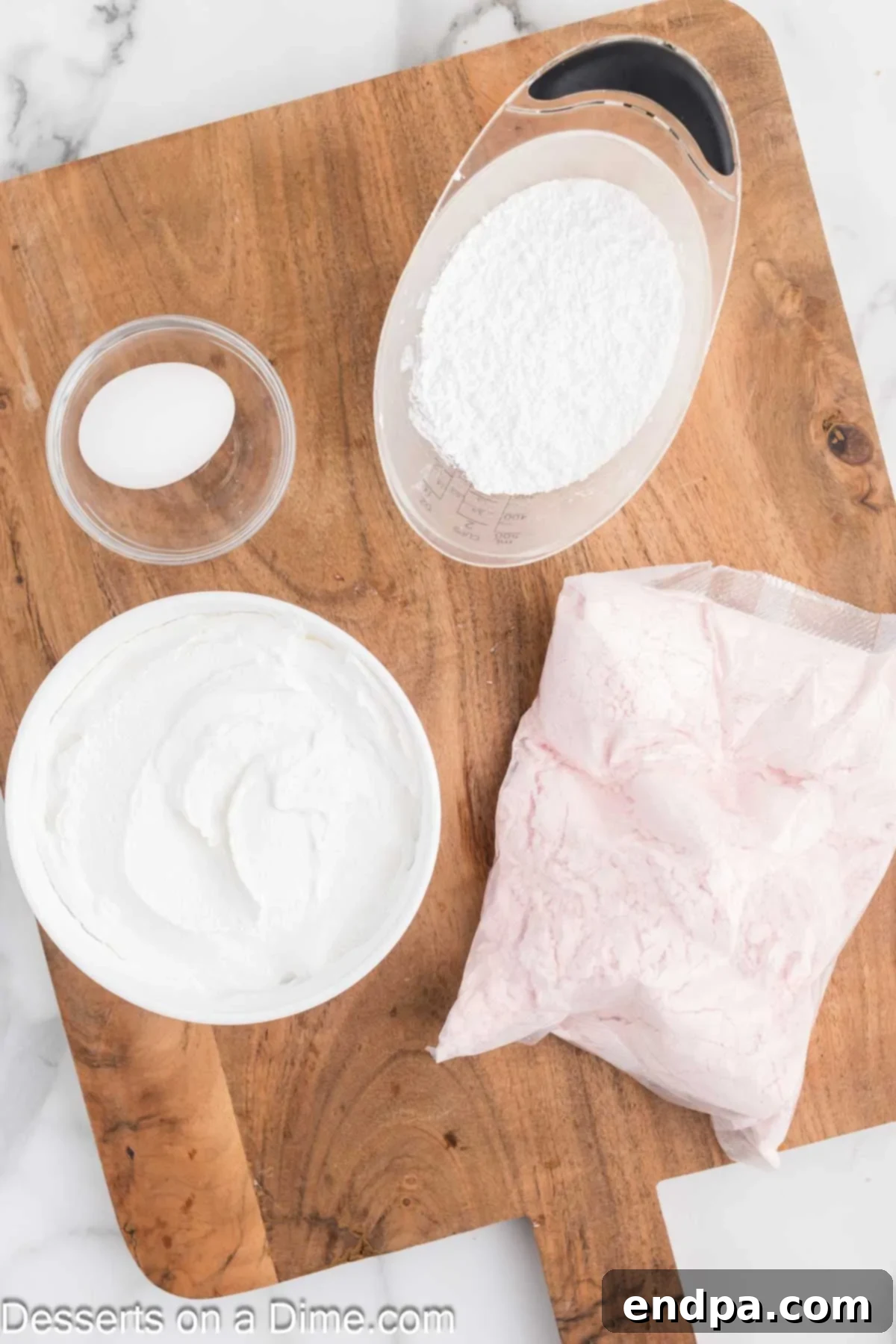 Ingredients for cake mix cookies - cake mix, cool whip, egg, powdered sugar, neatly displayed.