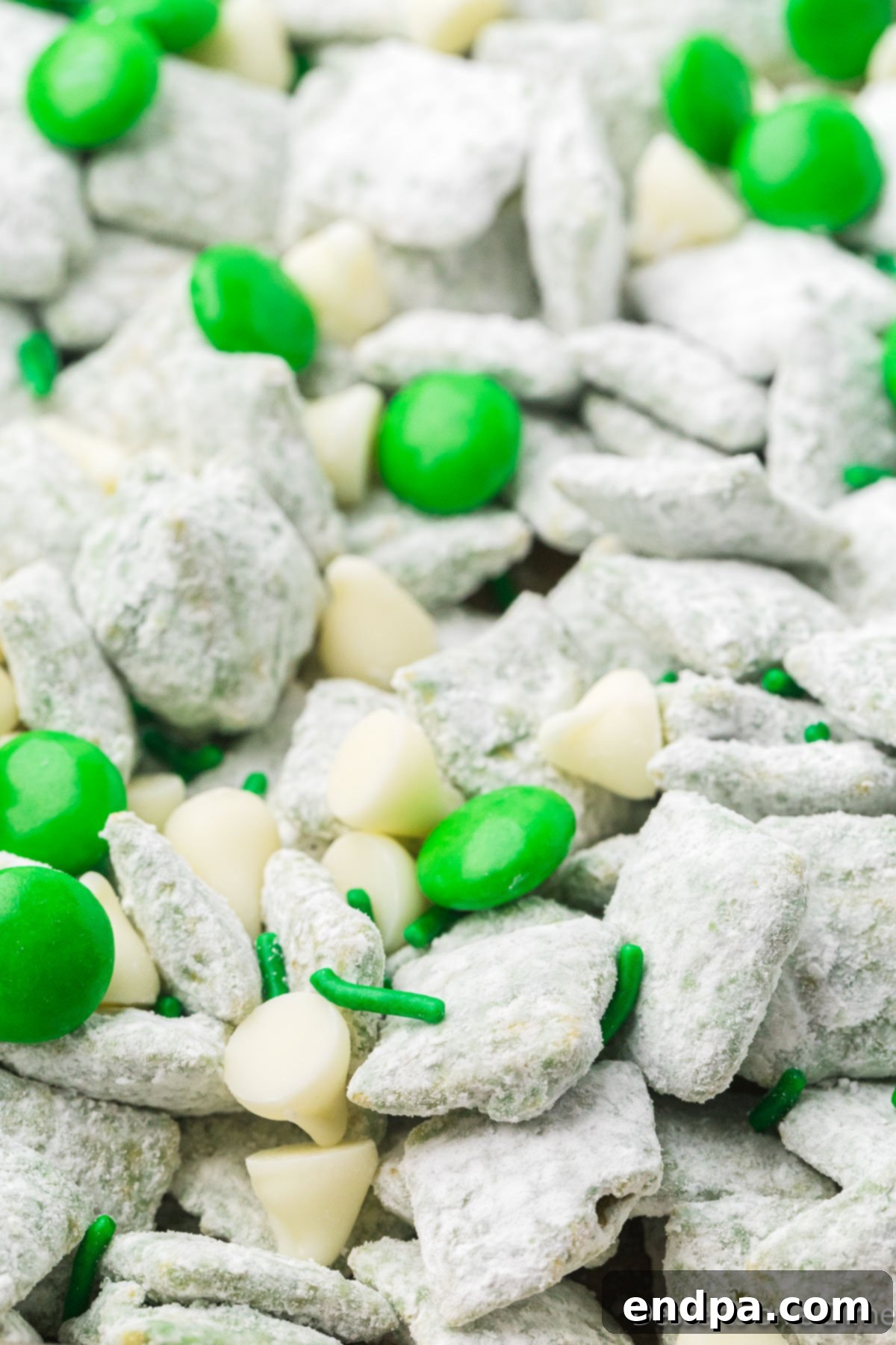 A beautifully arranged serving of St. Patrick's Day Puppy Chow in a decorative bowl, showcasing its festive green color and delicious toppings, ready to be enjoyed.