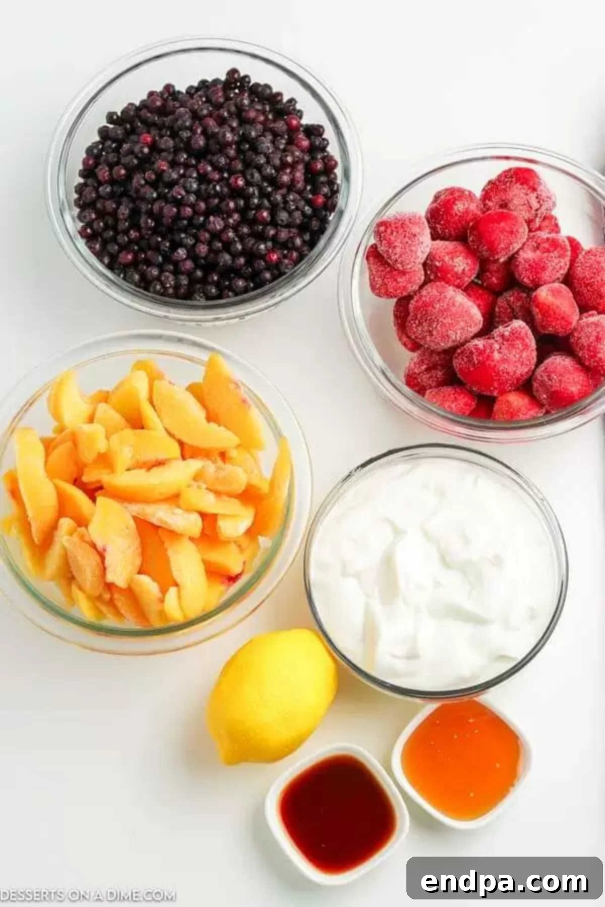 Cool & Creamy Homemade Frozen Yogurt 3 Assortment of fresh and frozen ingredients laid out, including fruit, yogurt, and honey, for making frozen yogurt.