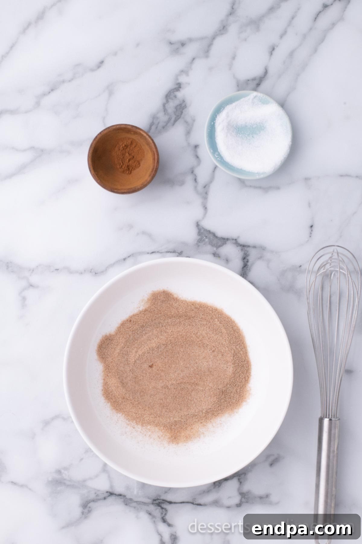 Golden Crispy Elephant Ears Delight 12 A small mixing bowl holds a perfectly blended mixture of granulated sugar and ground cinnamon.