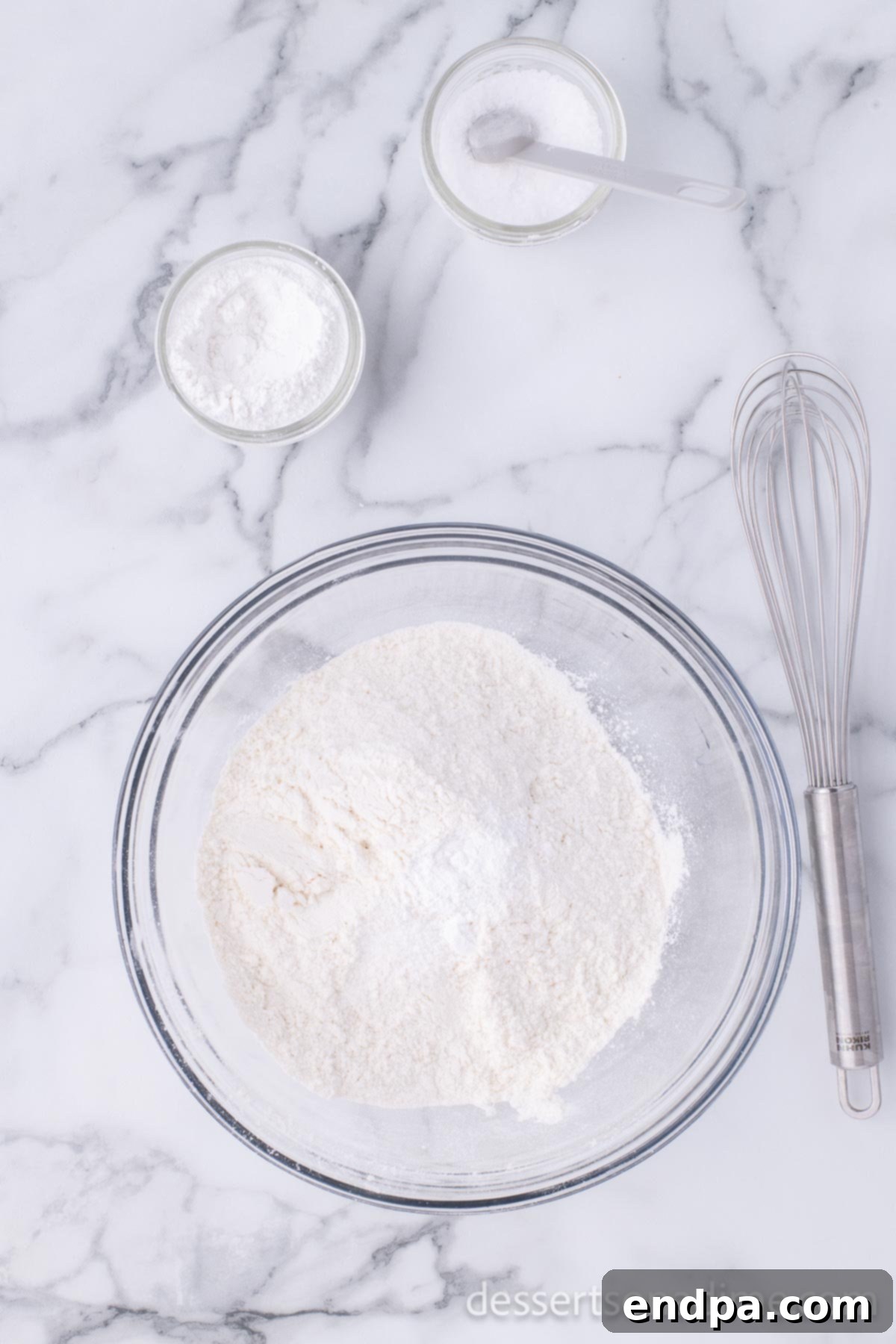 Golden Crispy Elephant Ears Delight 4 A medium mixing bowl contains dry ingredients – flour, salt, and baking powder – stirred together to ensure even distribution.