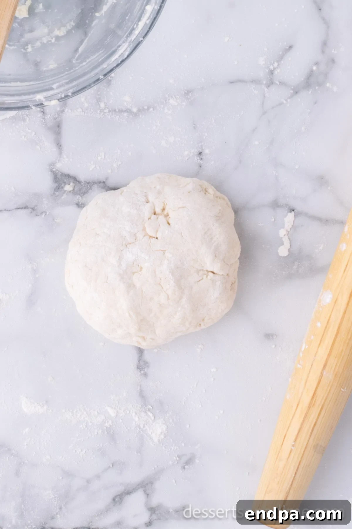 Golden Crispy Elephant Ears Delight 6 The newly formed dough, shaped into a smooth ball, is resting on a clean countertop, ready for the next stage.
