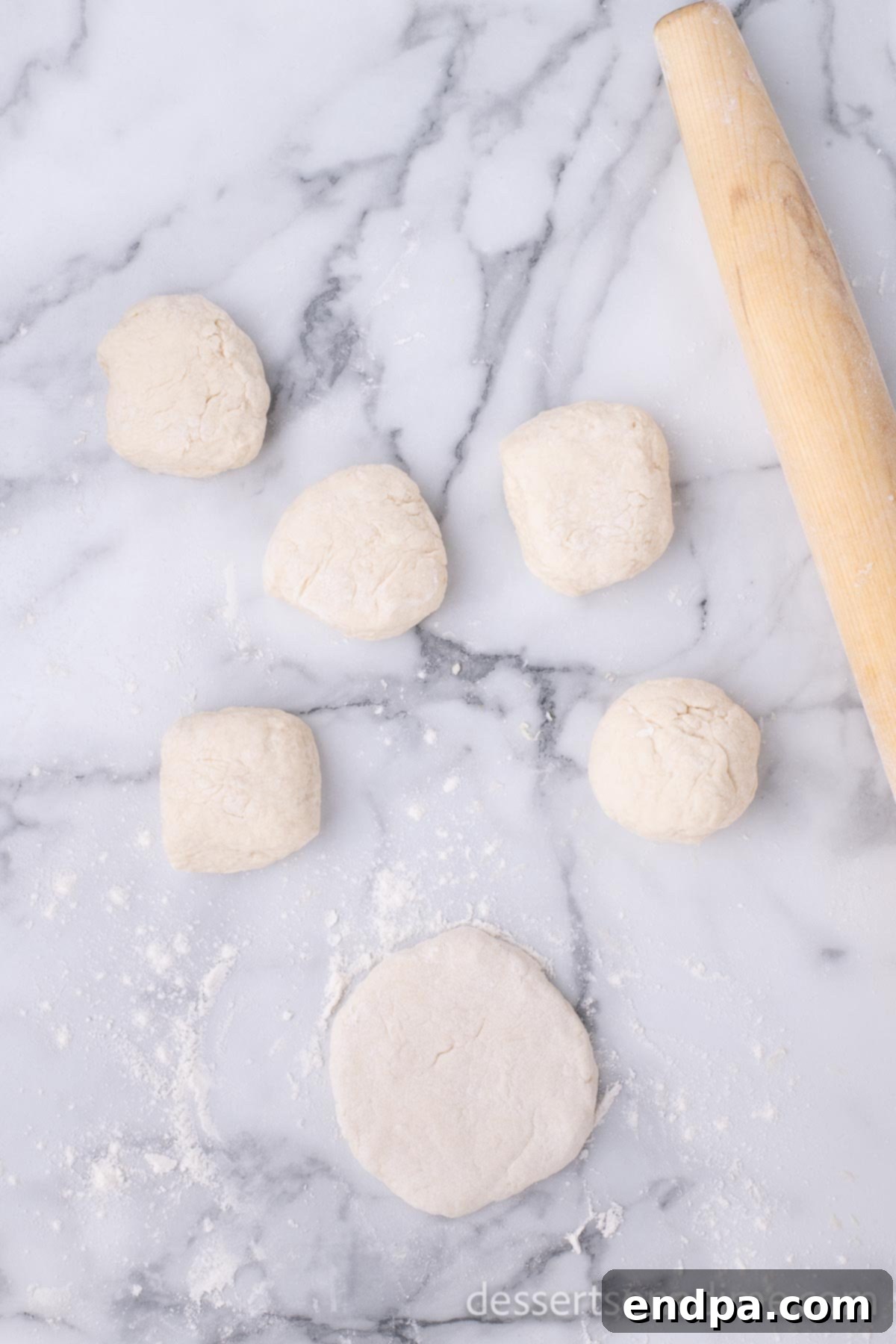 Golden Crispy Elephant Ears Delight 8 Each portion of dough is shaped into a ball, with one ball flattened into a circular disc approximately half an inch thick.