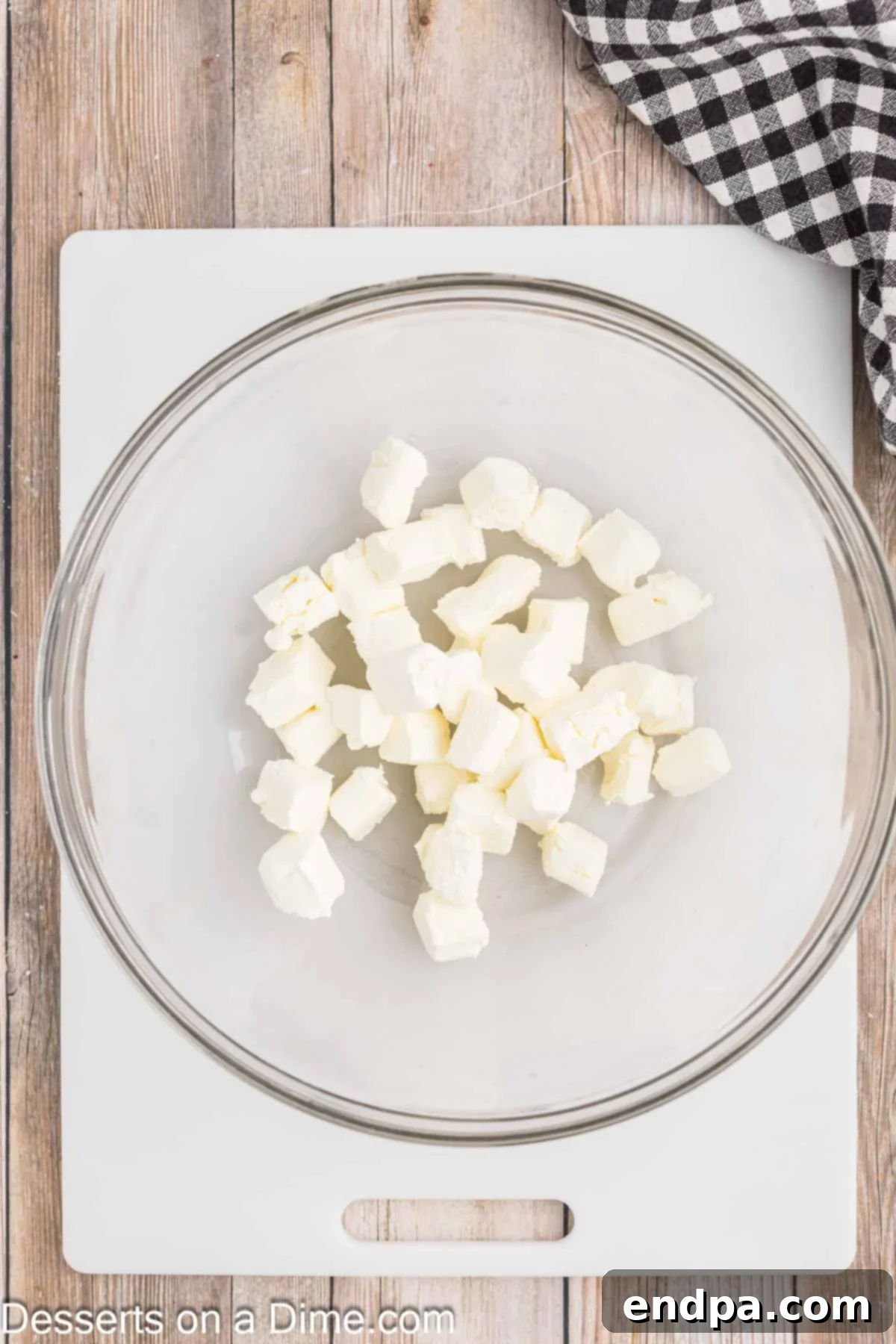 Effortless Ways to Soften Cream Cheese 6 Cubes of cream cheese placed in a microwave-safe bowl.