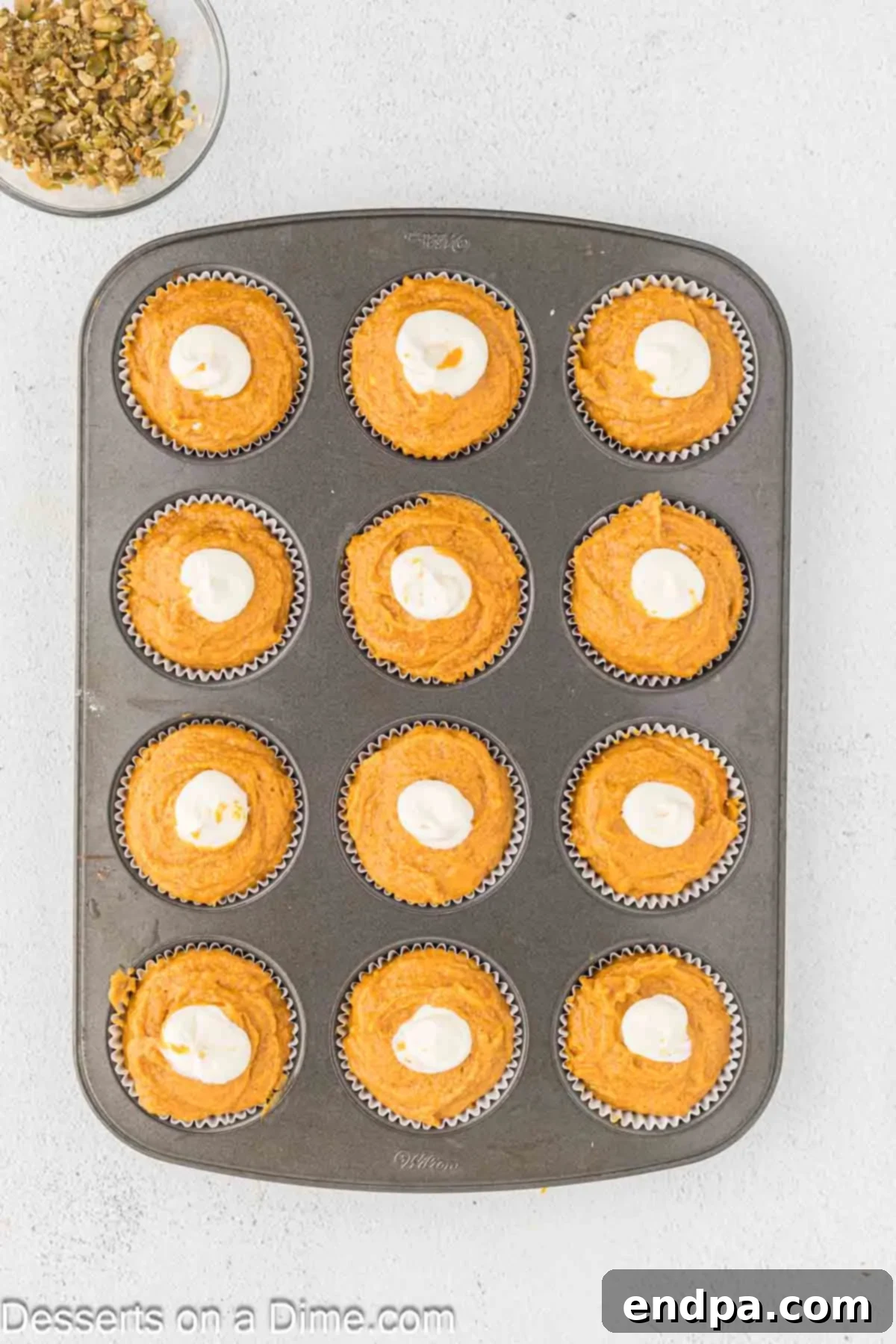 Starbucks-Style Pumpkin Spice Cream Cheese Muffins 11 Cream cheese filling piped as a dollop into the center of each pumpkin muffin batter.