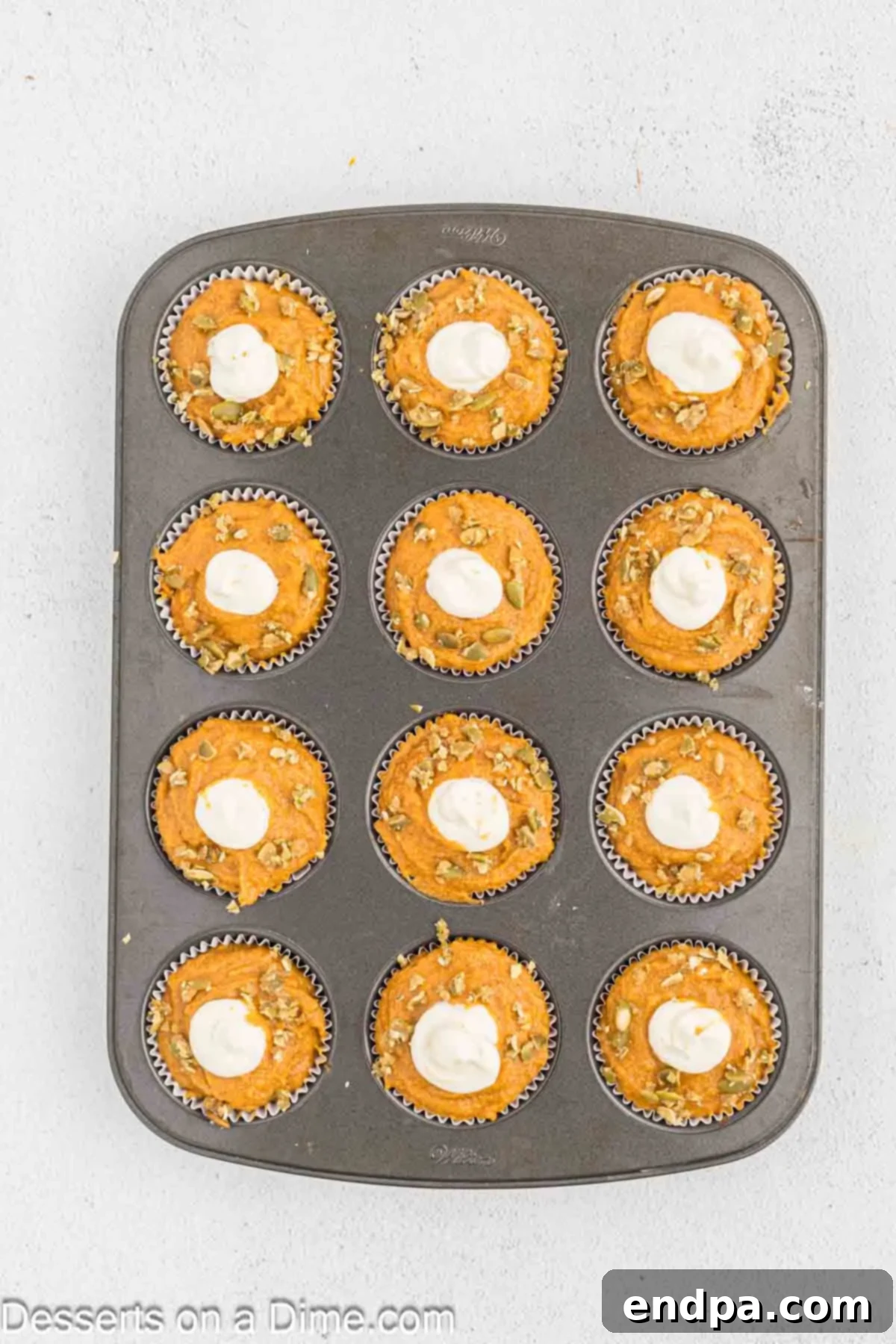 Starbucks-Style Pumpkin Spice Cream Cheese Muffins 12 Toasted pumpkin seeds sprinkled over the cream cheese filling on top of each unbaked pumpkin muffin.