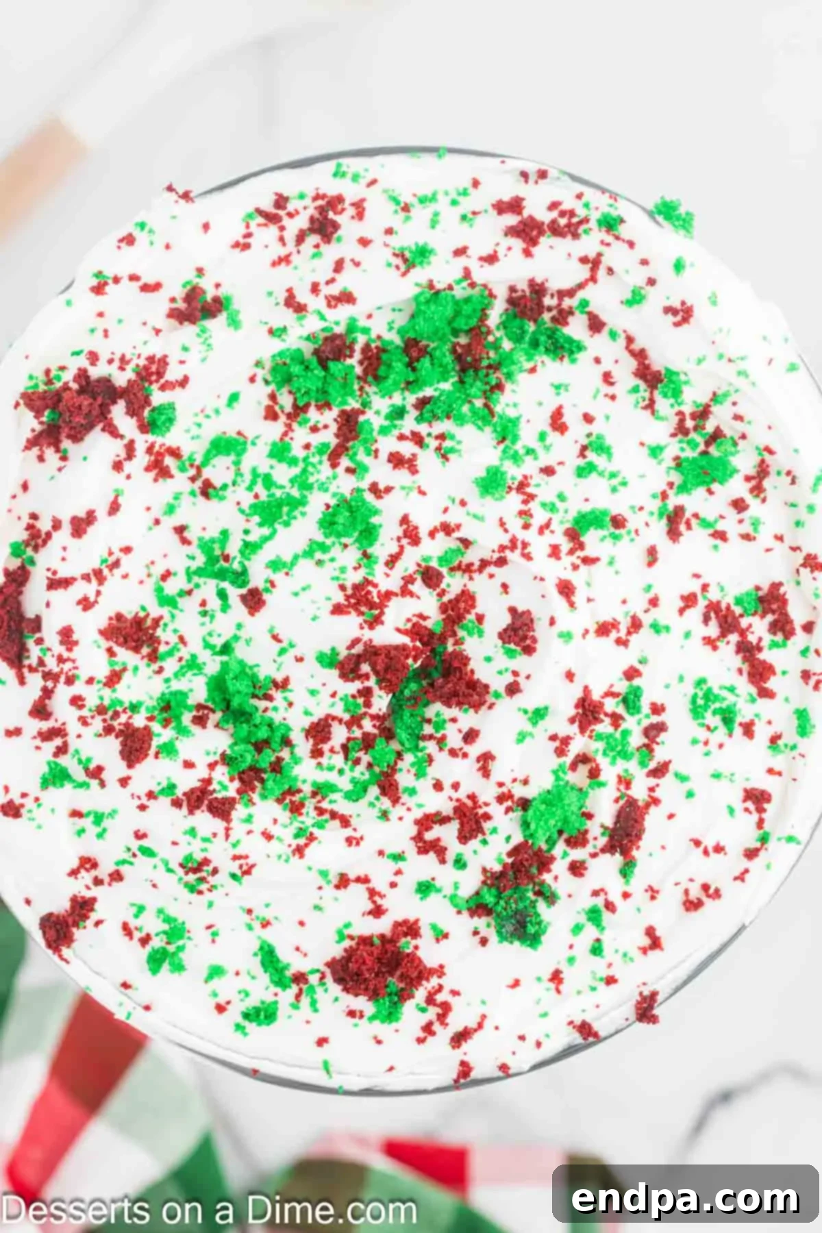 Final layer of whipped cream and reserved cake crumbs on top of the trifle.