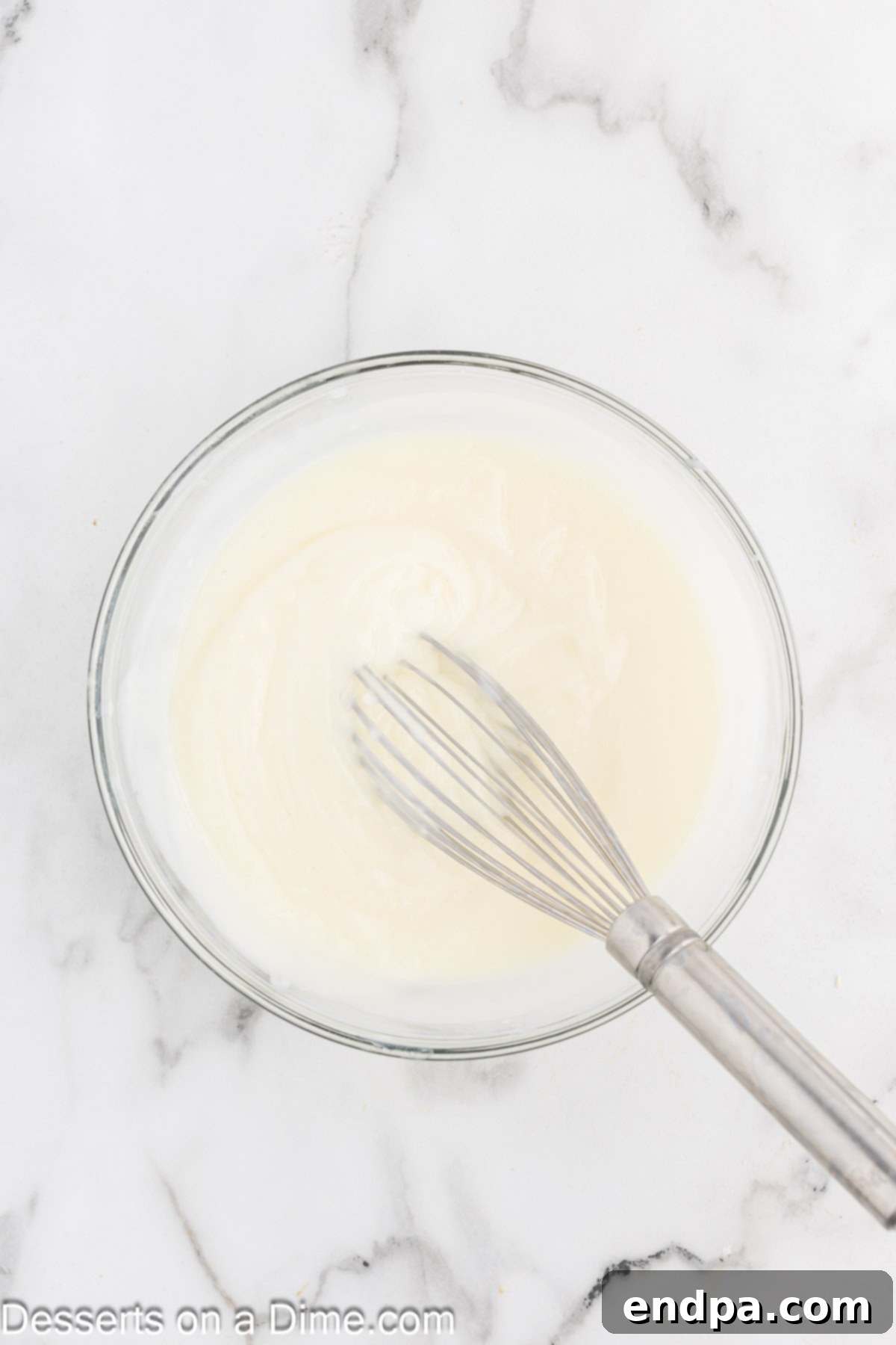 White chocolate pudding mix combined with milk in a bowl and whisked.