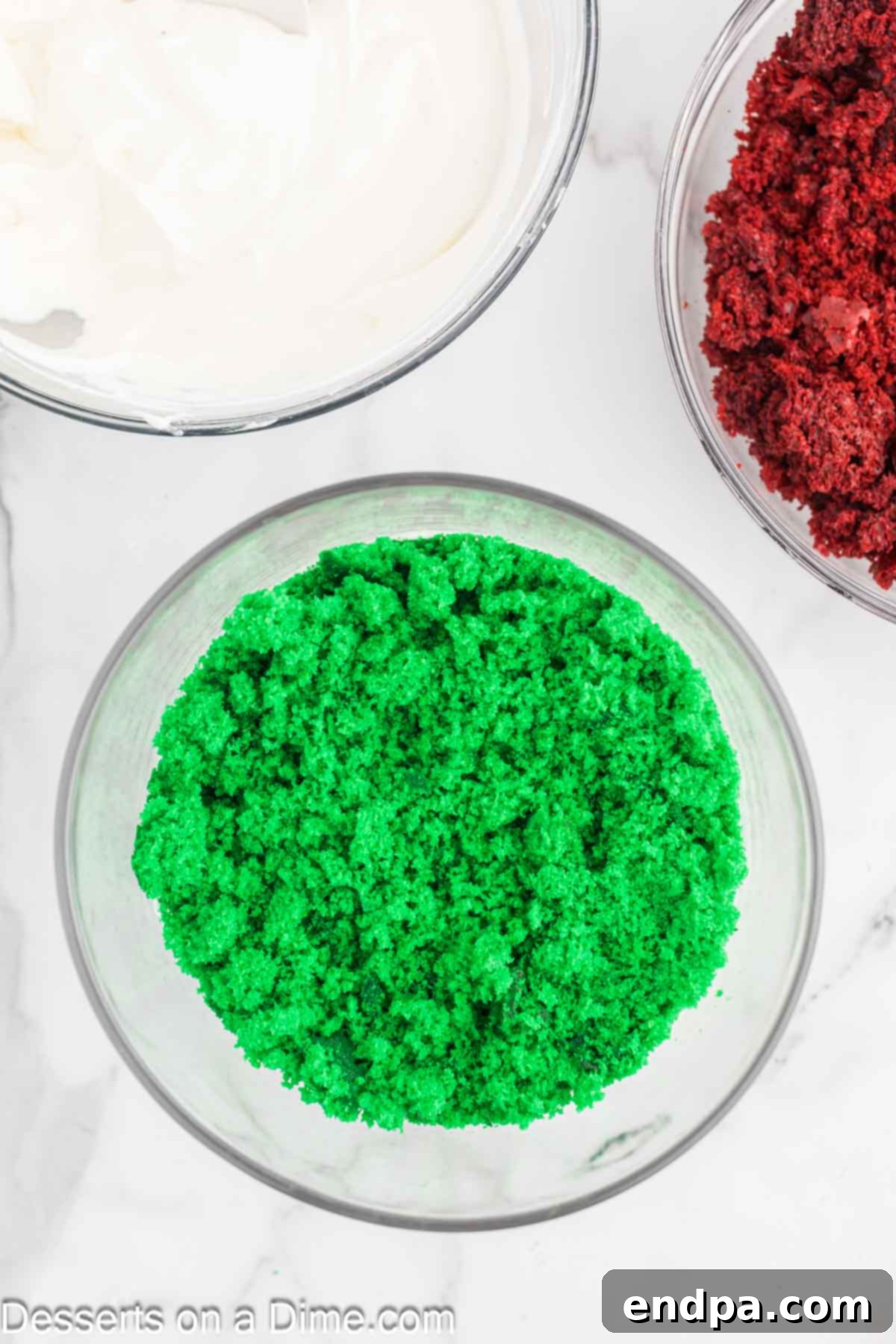 Green cake crumbs layered on top of the white chocolate mixture.
