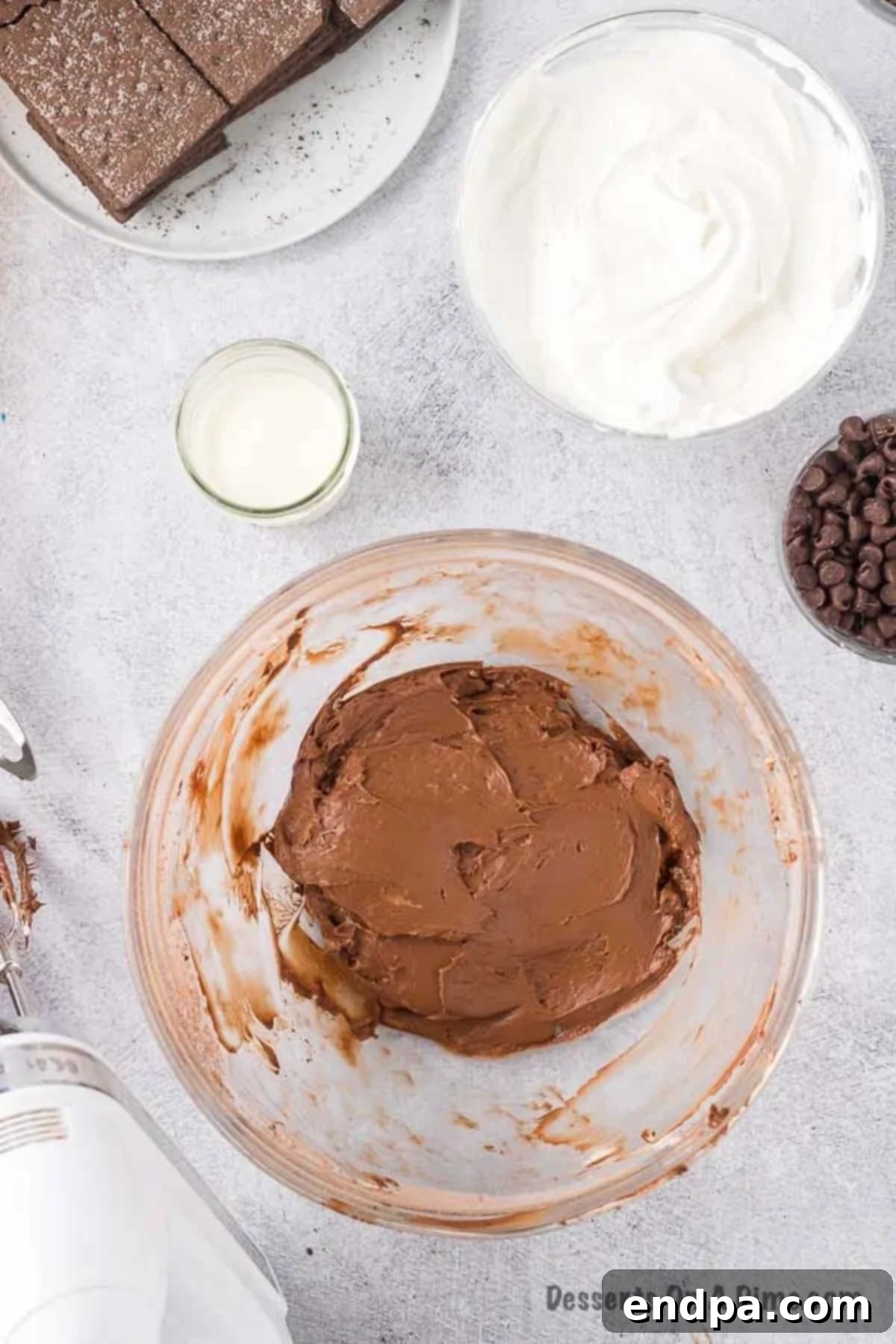 Cream cheese mixture in a bowl with powdered sugar and cocoa powder.