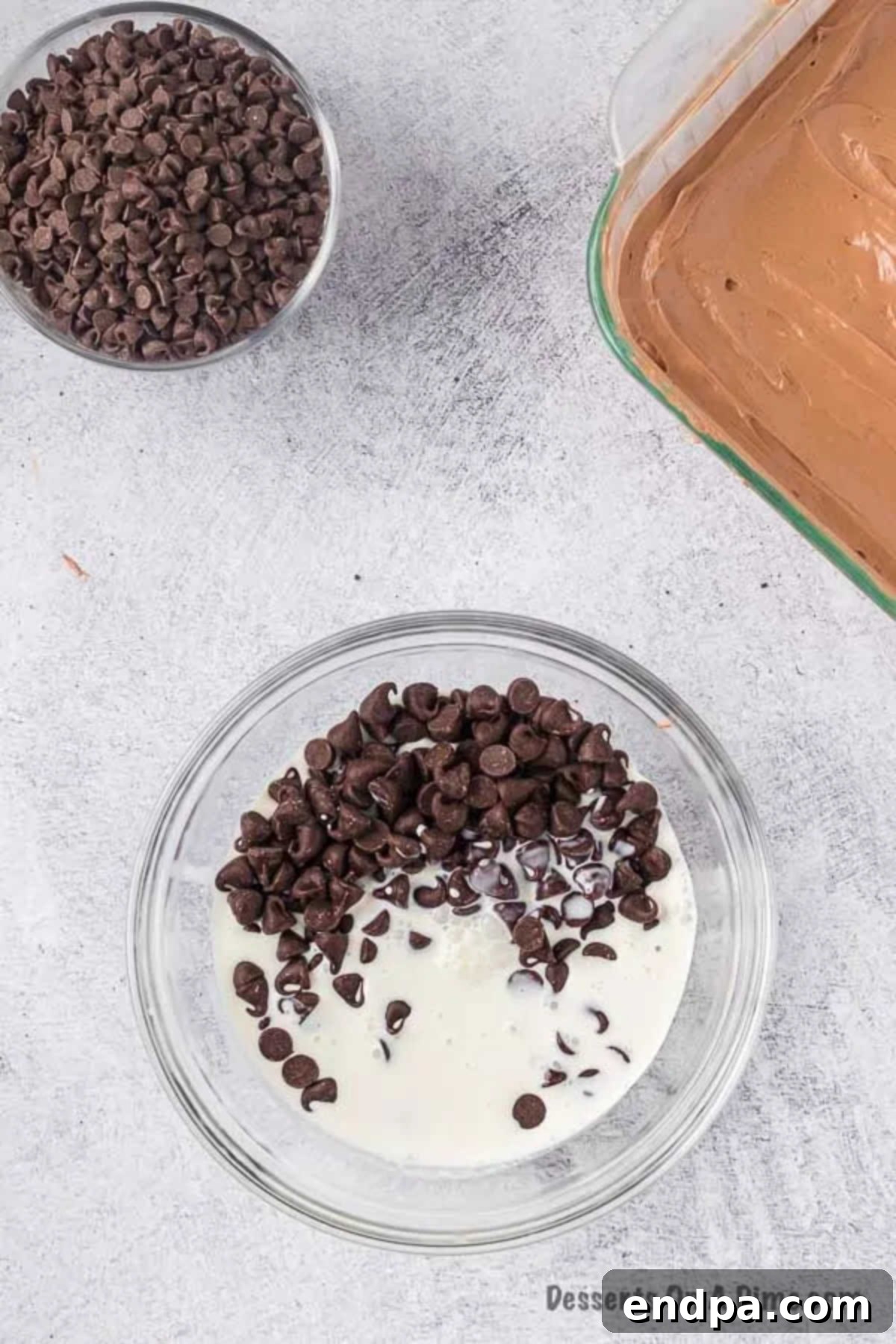 Chocolate chips and heavy cream in a microwave-safe bowl, ready to be melted for ganache.