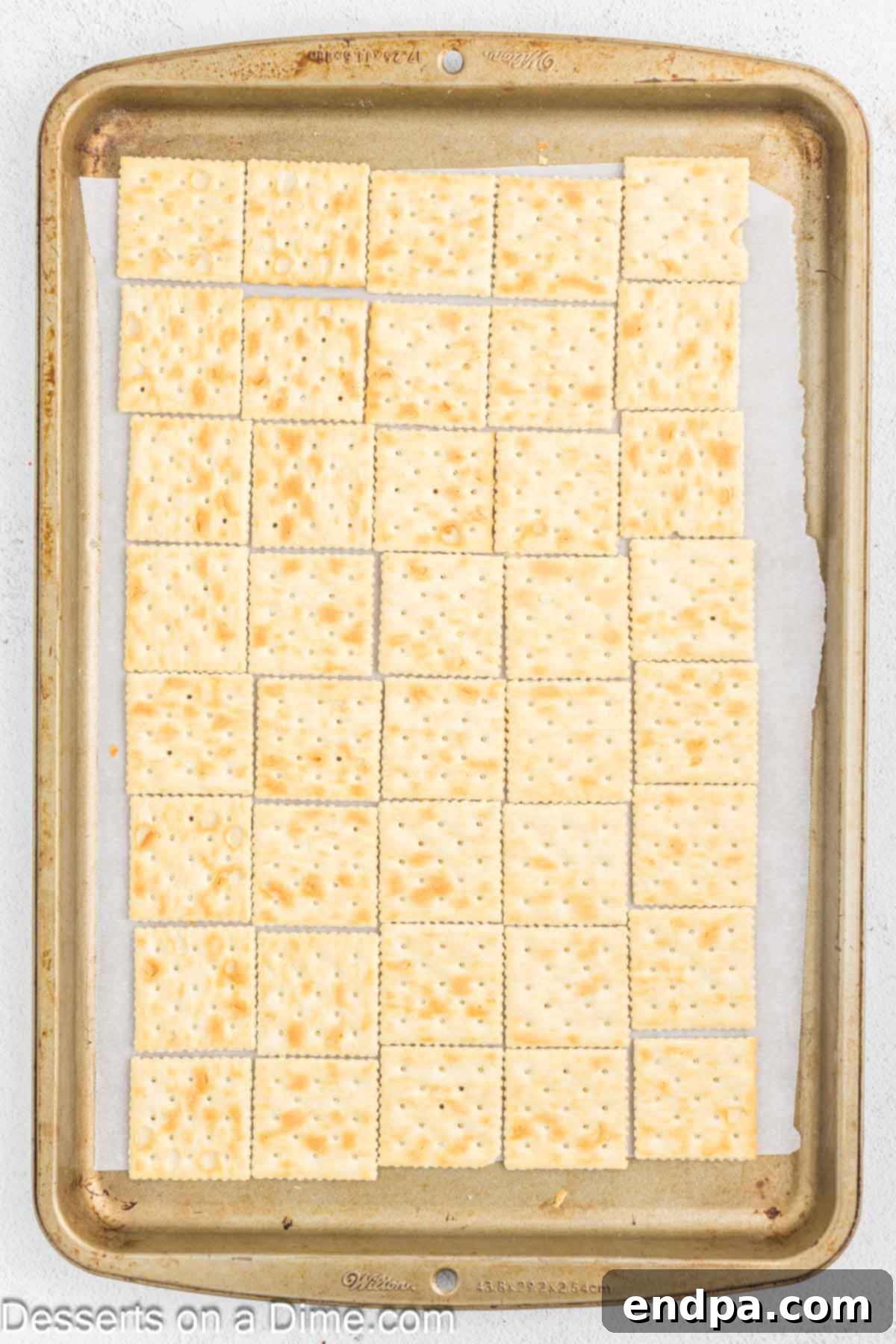 Sweet and Salty Toffee Bark 4 Saltine crackers arranged in a single layer on a foil-lined baking sheet, ready for the toffee mixture.