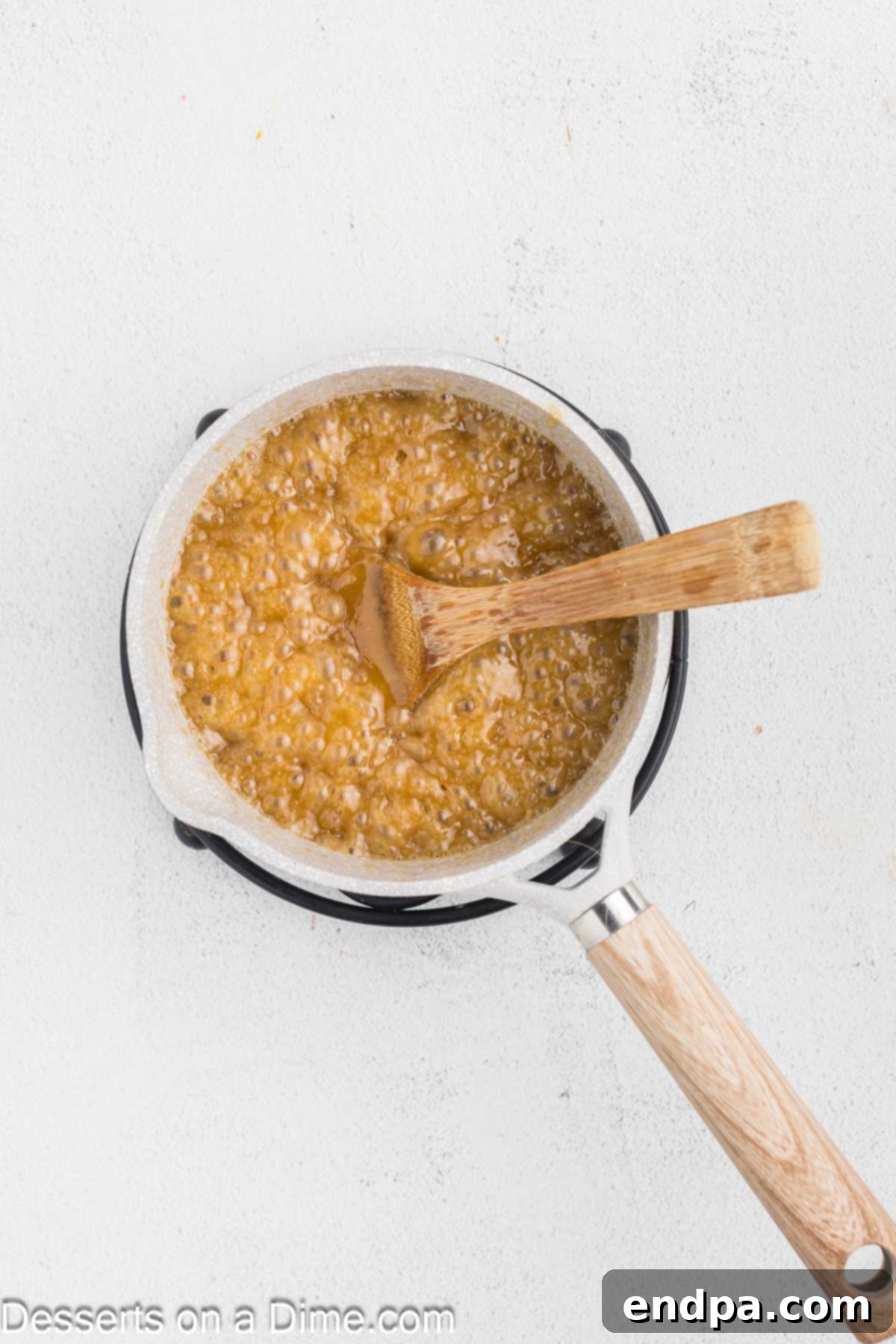Sweet and Salty Toffee Bark 5 Brown sugar and melted butter simmering together in a saucepan on a stovetop, forming the toffee base.
