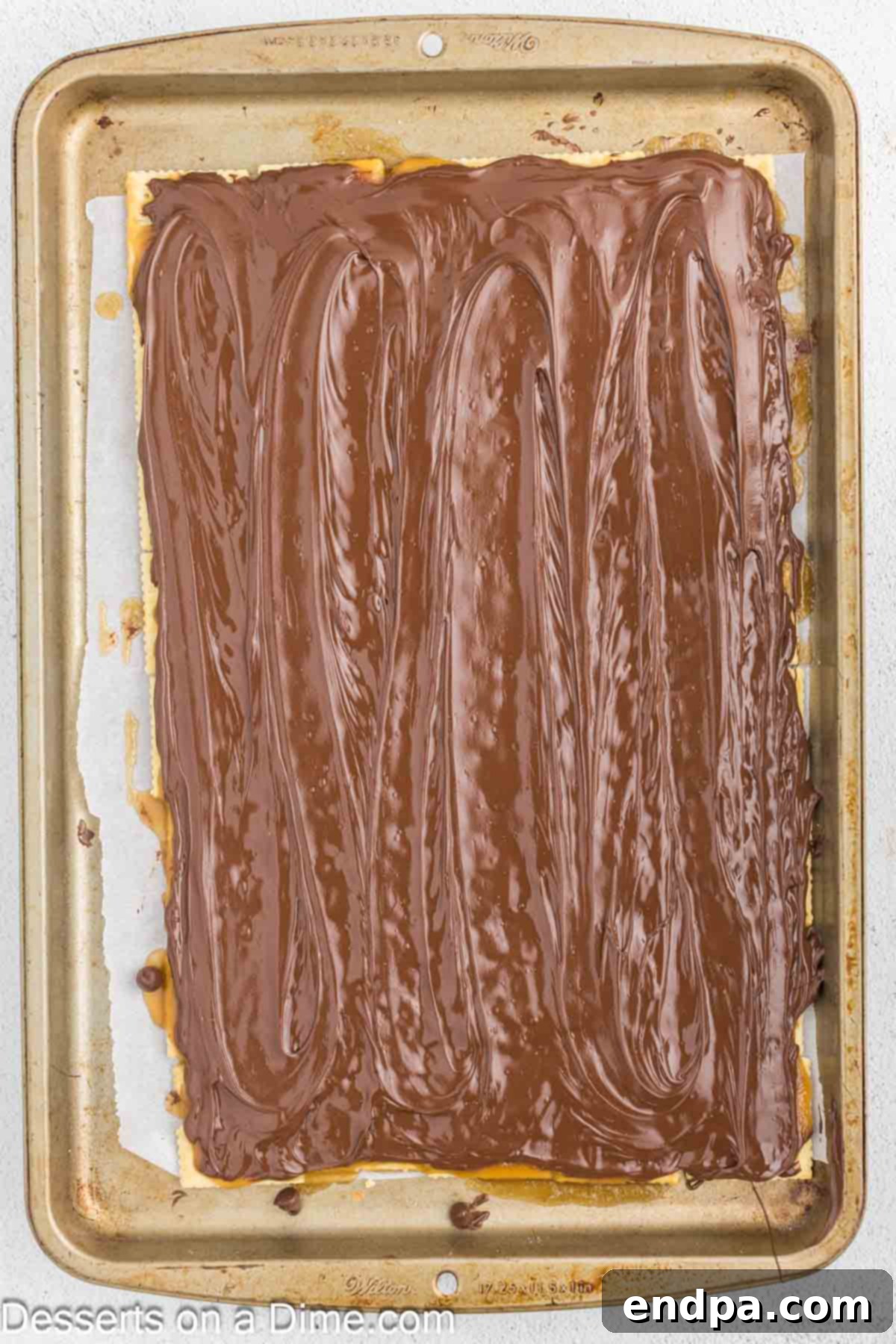 Sweet and Salty Toffee Bark 8 Melted chocolate smoothly spread over the toffee and cracker base using an offset spatula.