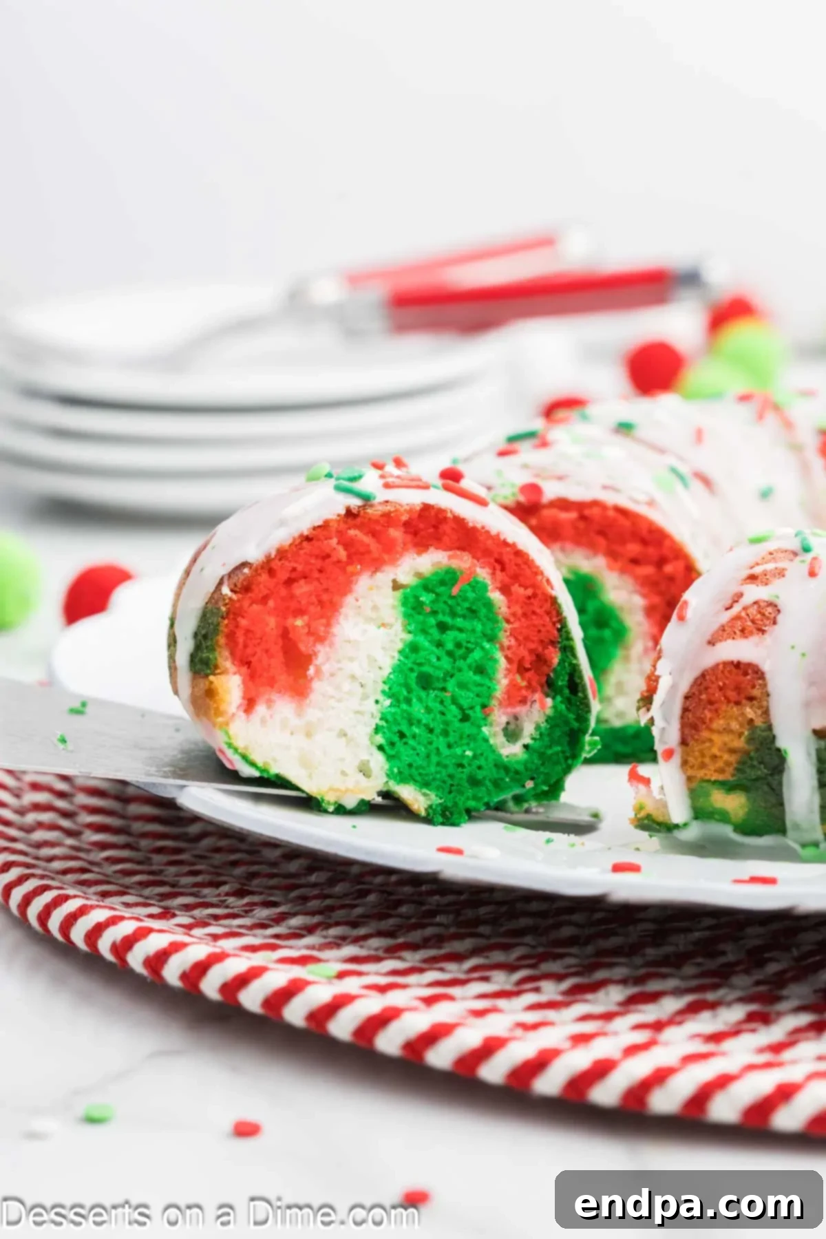 A slice of Christmas Bundt cake being served on a white plate with a festive design.