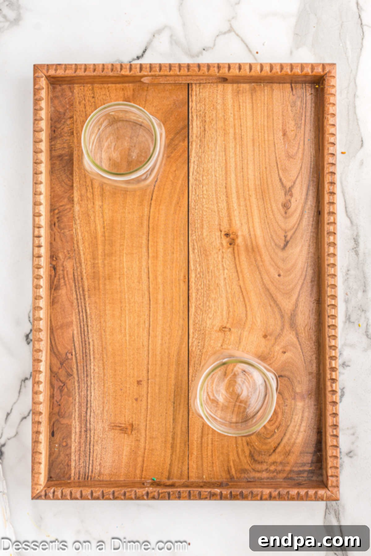 A large wooden charcuterie board with small empty bowls arranged, ready for toppings.