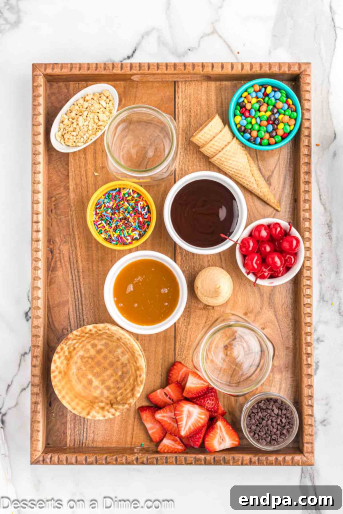 Various small bowls filled with colorful toppings like sprinkles, candies, and sauces are arranged on a charcuterie board.