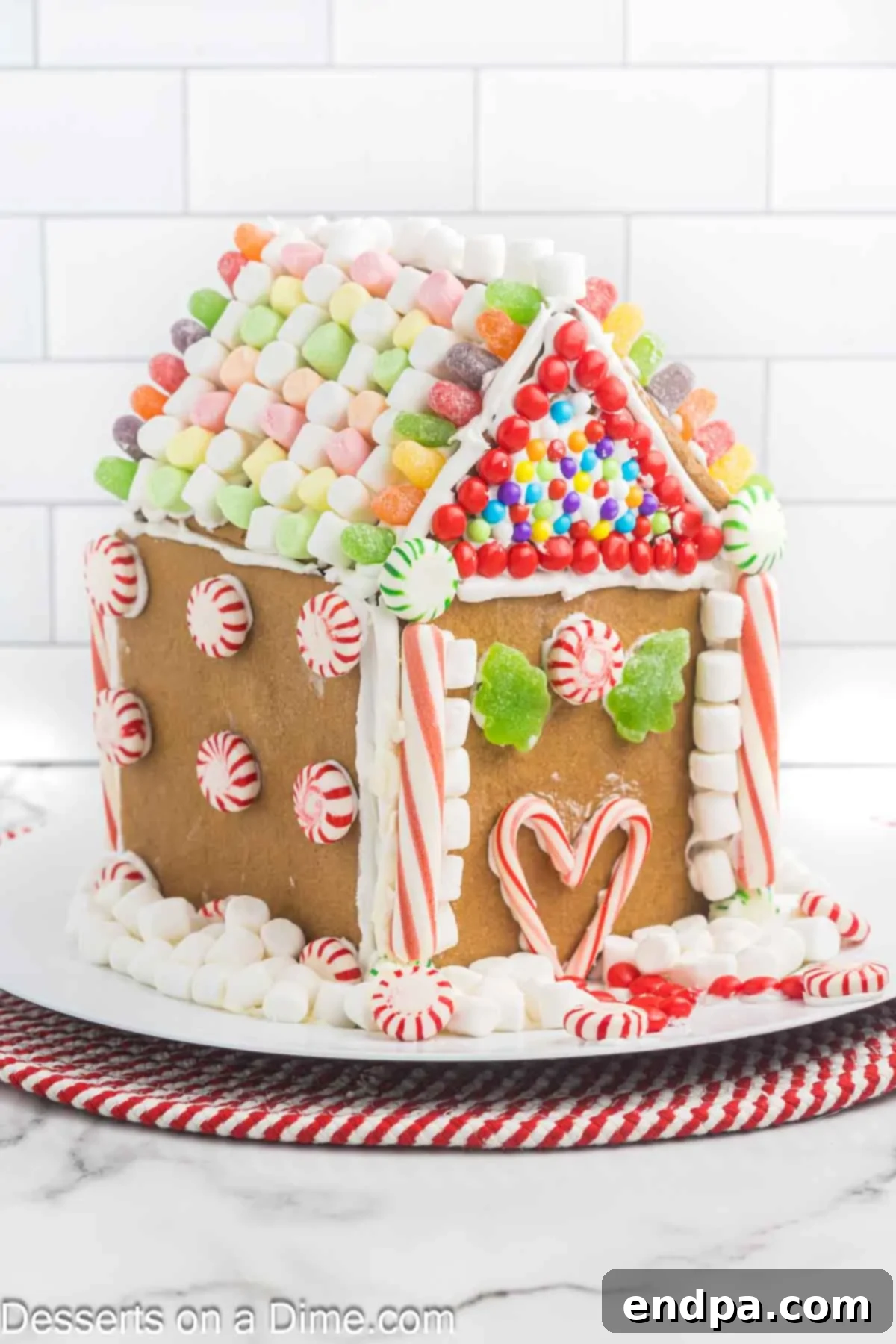 Spiced Sugar Sanctuary 14 A partially decorated gingerbread house, with some buttercream frosting applied and a few candies added, showcasing the beginning of the festive adornment.