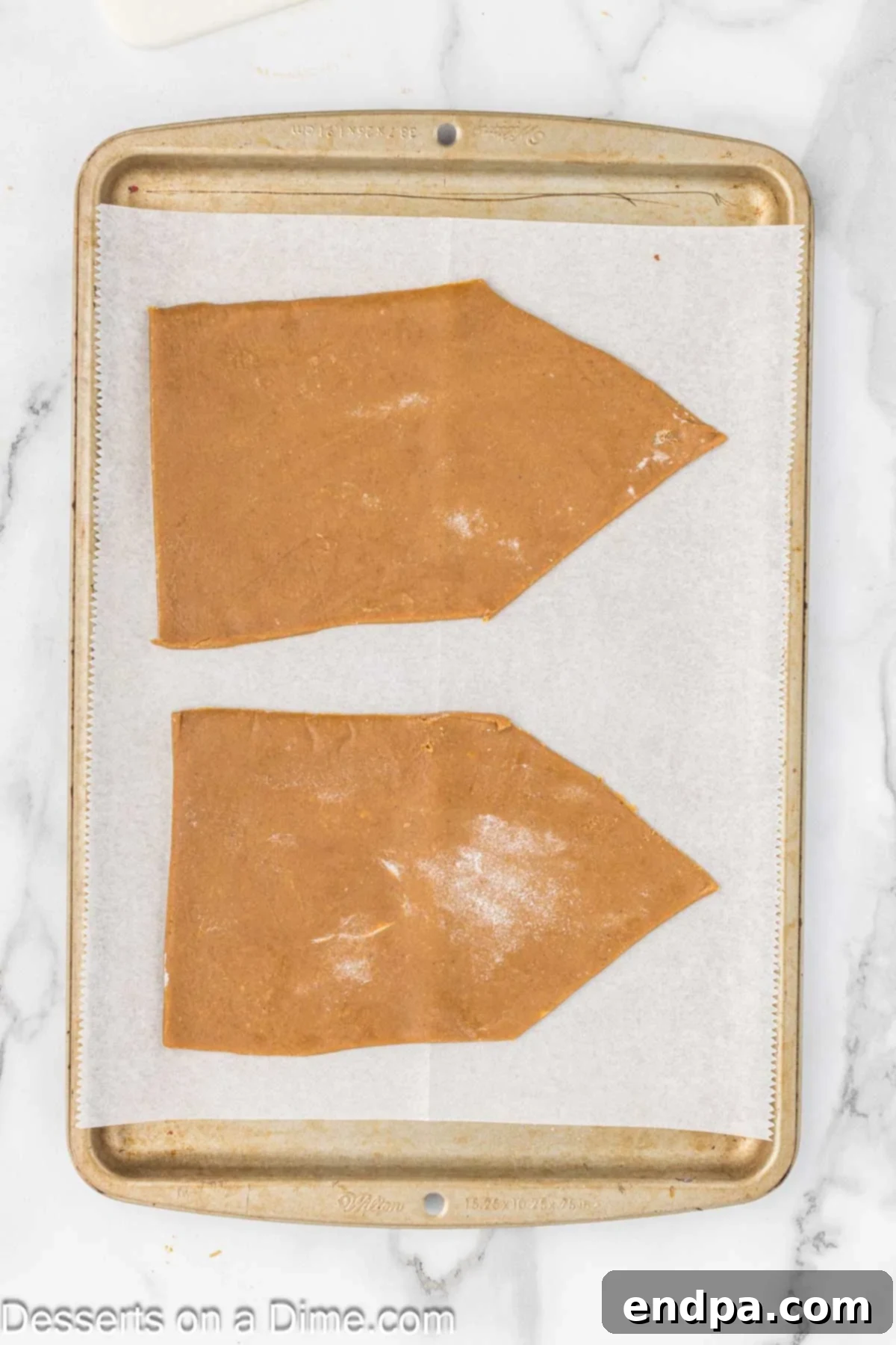 Spiced Sugar Sanctuary 8 Gingerbread pieces, neatly cut into house components, arranged on a baking sheet lined with parchment paper, ready for baking.