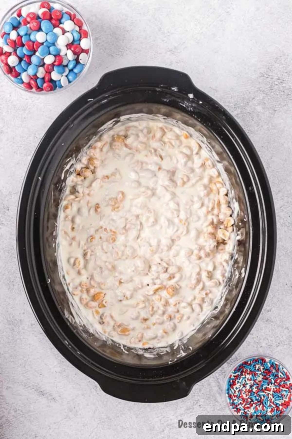 Melted chocolate and peanut mixture in the crock pot, smooth and ready for M&Ms.