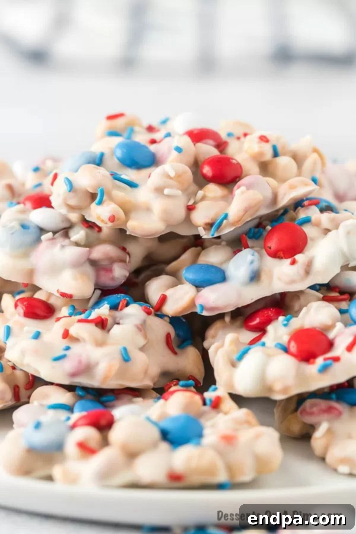 Crock Pot clusters decorated with M&M's and sprinkles, stacked on top of a serving platter, ready to be enjoyed.