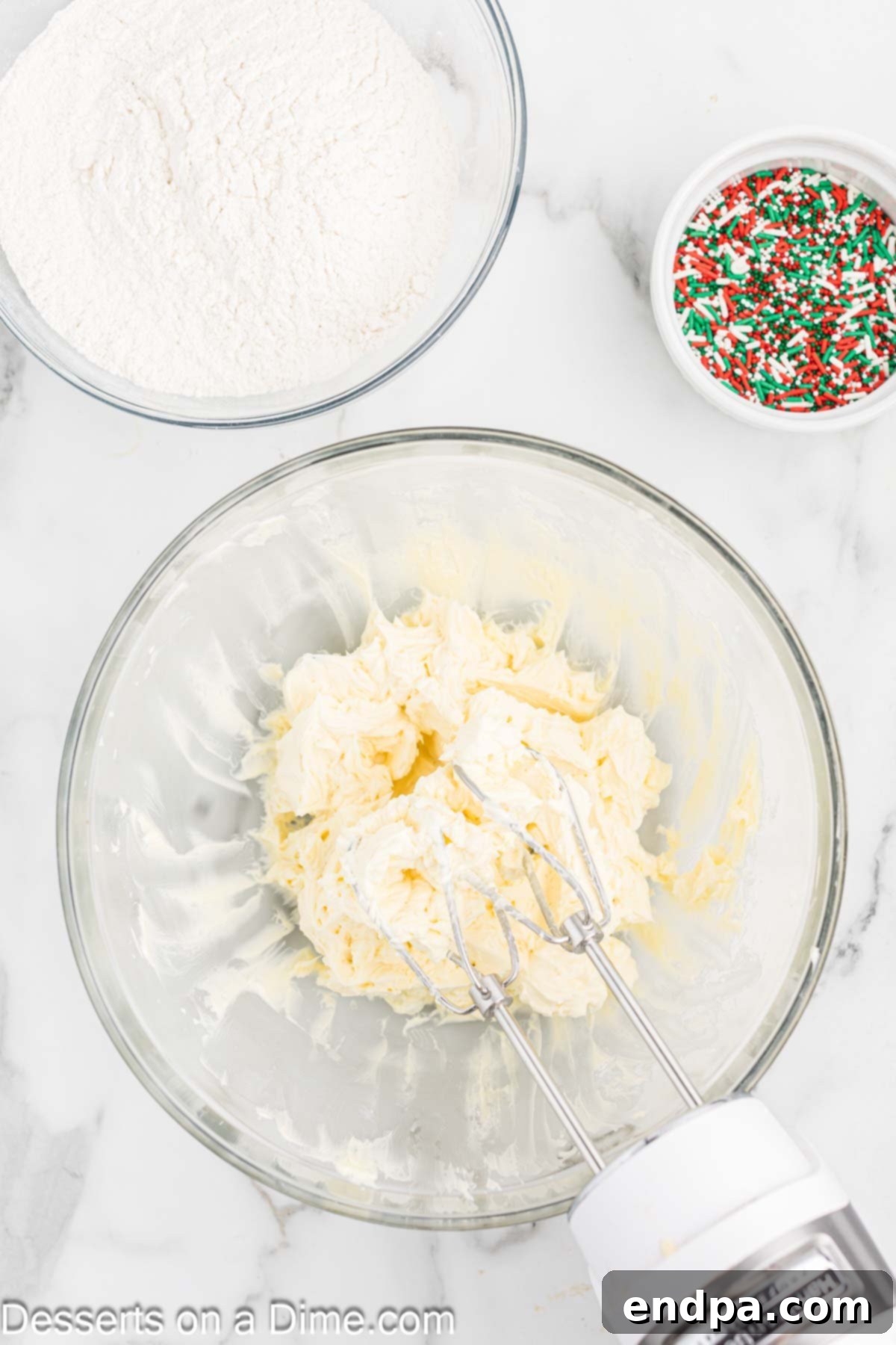 Buttery Christmas Shortbread Delights 4 Softened butter and powdered sugar being creamed together until light and fluffy in a stand mixer bowl.