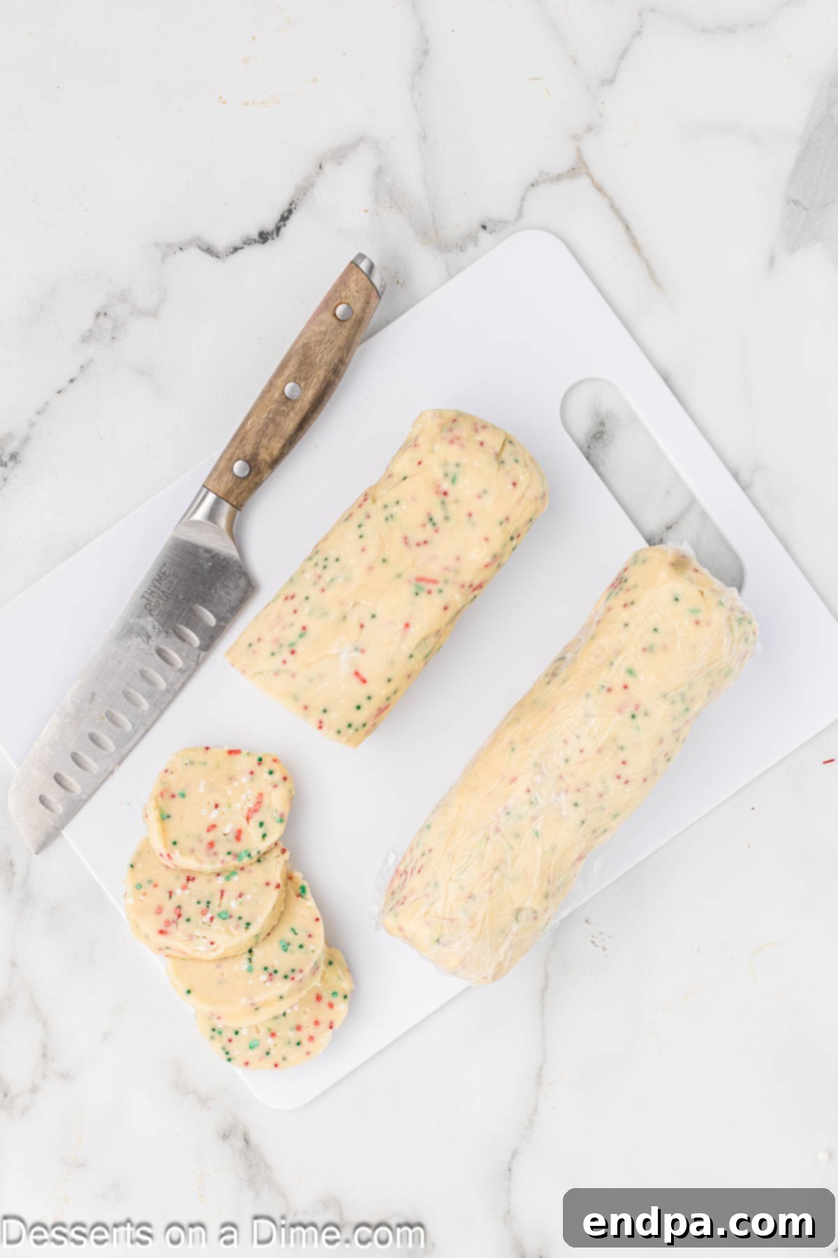Buttery Christmas Shortbread Delights 7 Shortbread dough formed into two logs and then sliced into uniform cookie rounds.