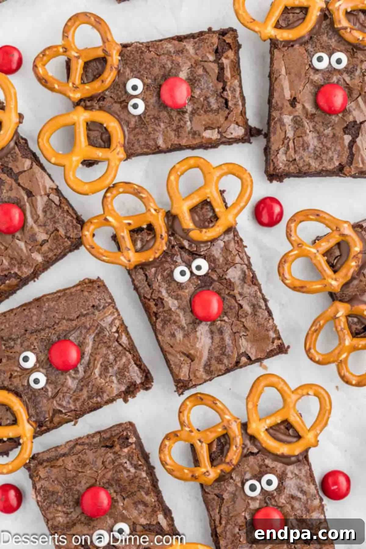 Christmas Antler Brownies 2 Collection of adorable Reindeer Brownies, each decorated like Rudolph with pretzel antlers, candy eyes, and a red M&M nose, arranged beautifully and ready to serve for Christmas.