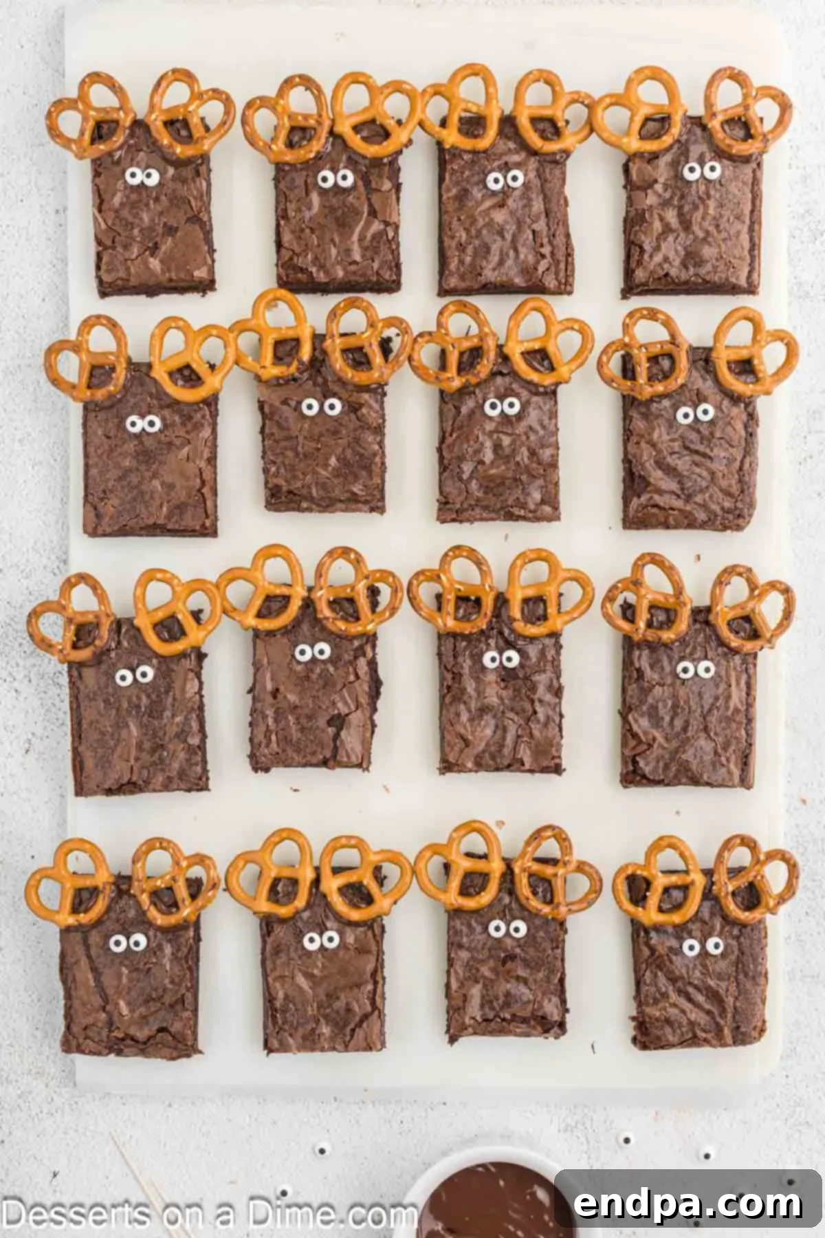 Christmas Antler Brownies 6 Individual brownie pieces with pretzel antlers, now featuring cute candy eyes secured with melted chocolate, bringing the reindeer faces to life.