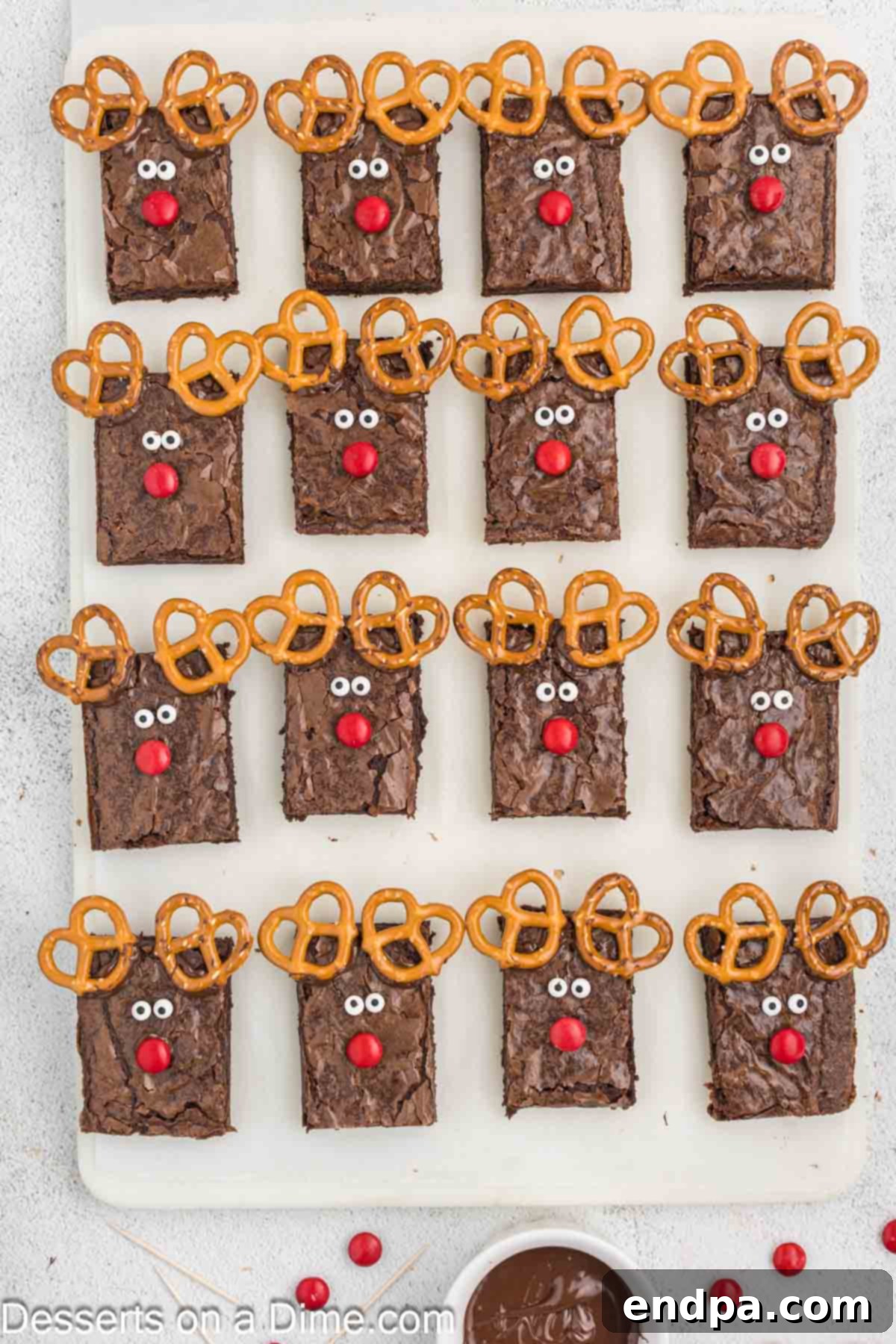 Christmas Antler Brownies 7 The final touch: red M&M's added to each brownie with antlers and candy eyes, completing the iconic Rudolph the Red-Nosed Reindeer look.
