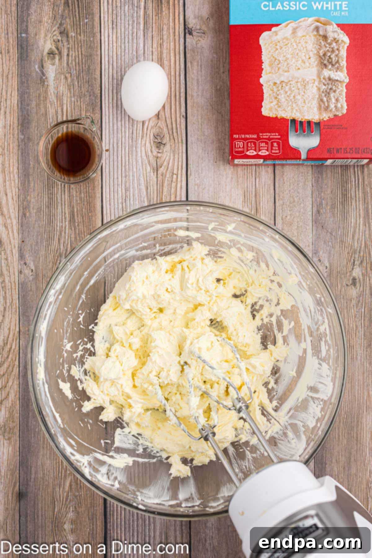 Creaming together softened cream cheese and butter in a bowl with a hand mixer.