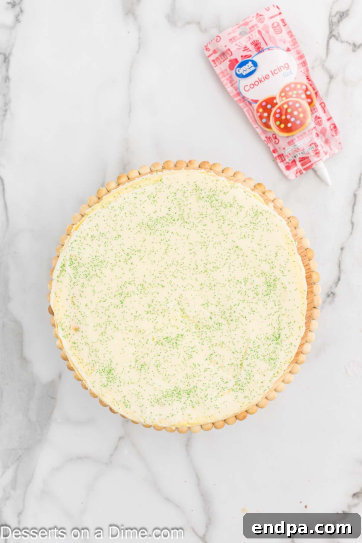 Ganache poured over cheesecake and topped with green sugar sprinkles. 