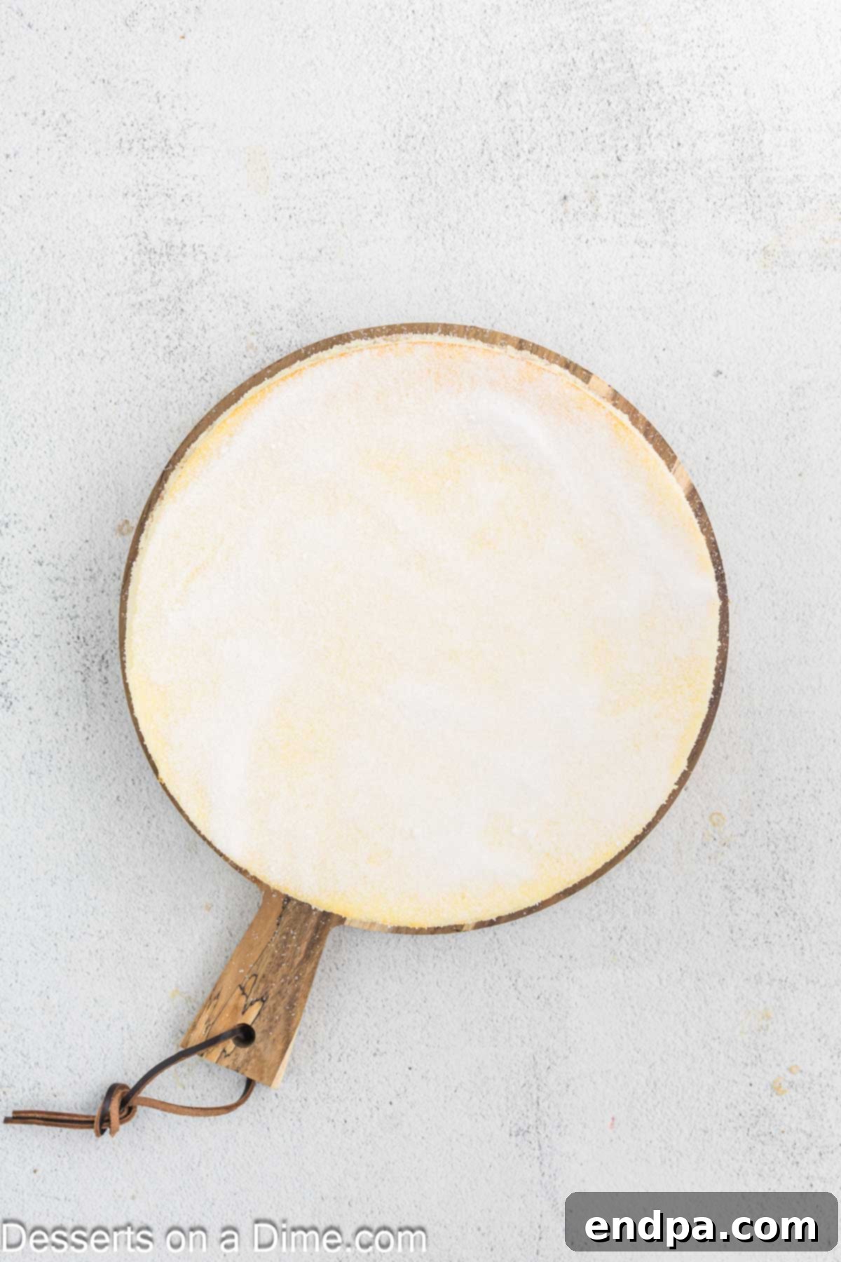 Crispy Caramel Cheesecake 11 Granulated sugar sprinkled evenly over the top of a chilled vanilla cheesecake, preparing for the brûlée torch.