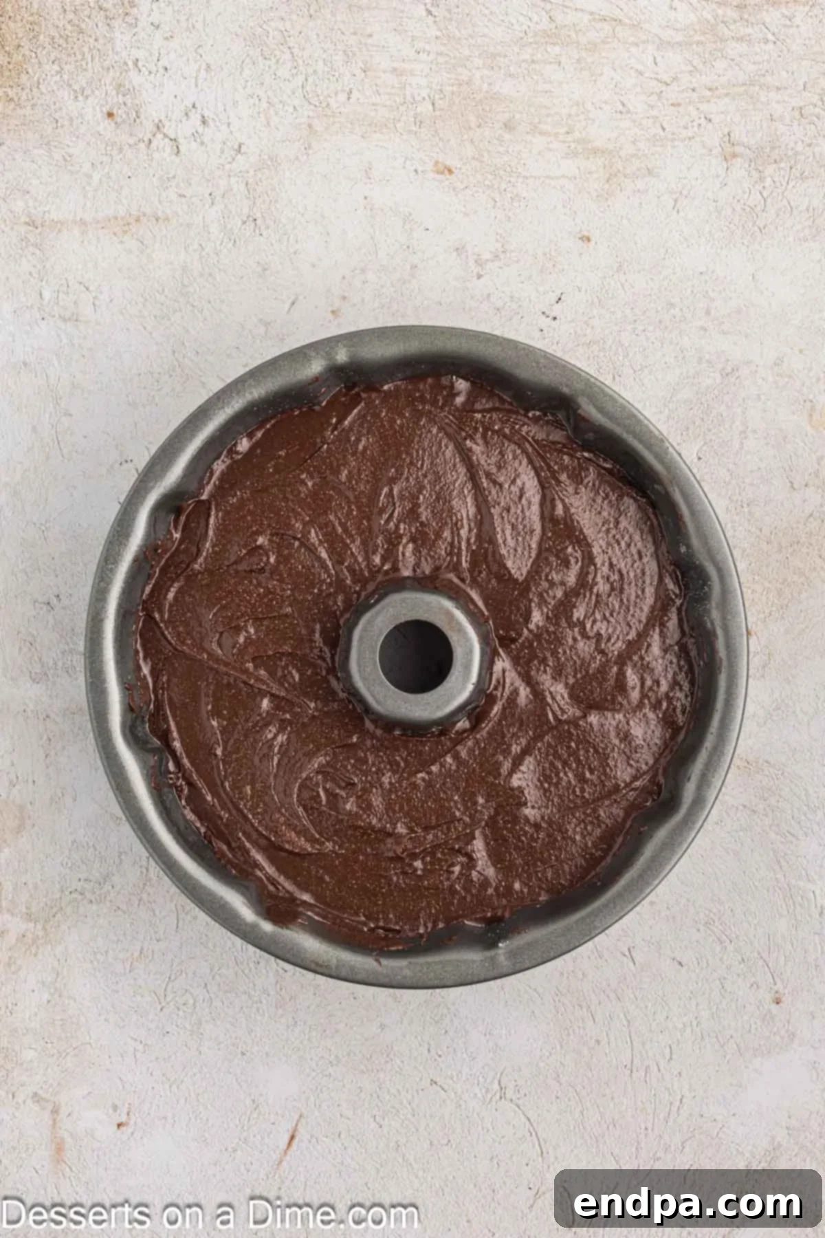 Velvet Chocolate Loaf 7 The smooth chocolate cake batter is poured evenly into the prepared bundt pan, ready for baking.