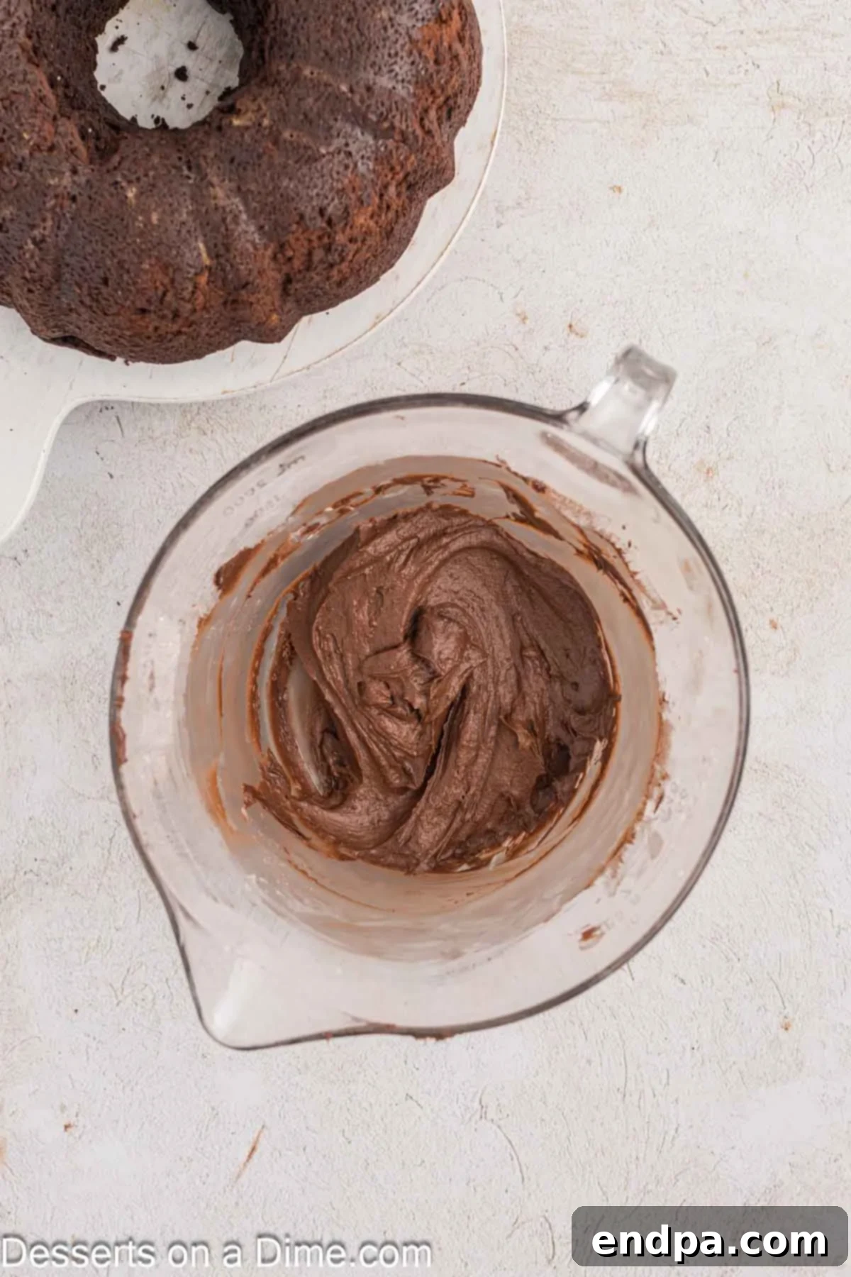 Velvet Chocolate Loaf 9 Ingredients for the rich chocolate frosting, including powdered sugar, cocoa, melted butter, and heavy cream, combined in a bowl.