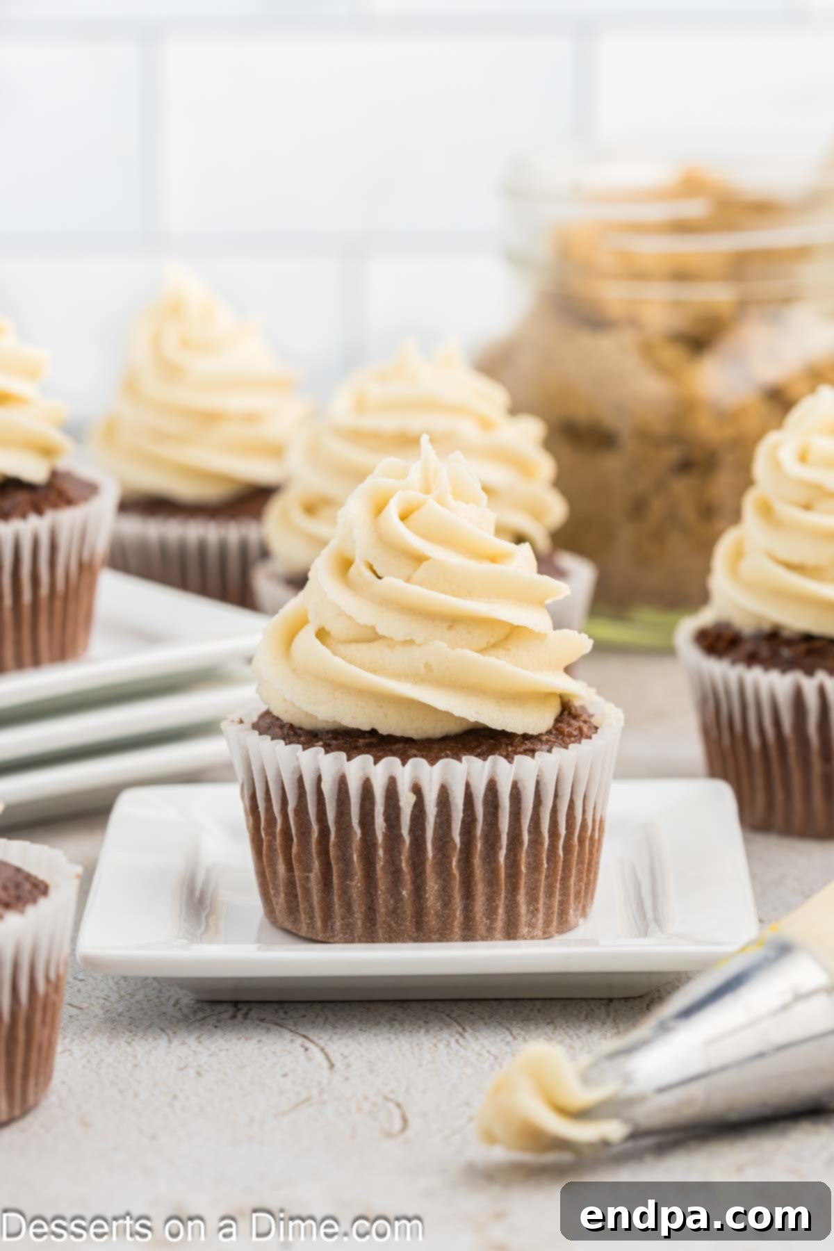 Golden Brown Sugar Buttercream 7 A perfectly piped swirl of brown sugar frosting on a chocolate cupcake, topped with a few walnuts.