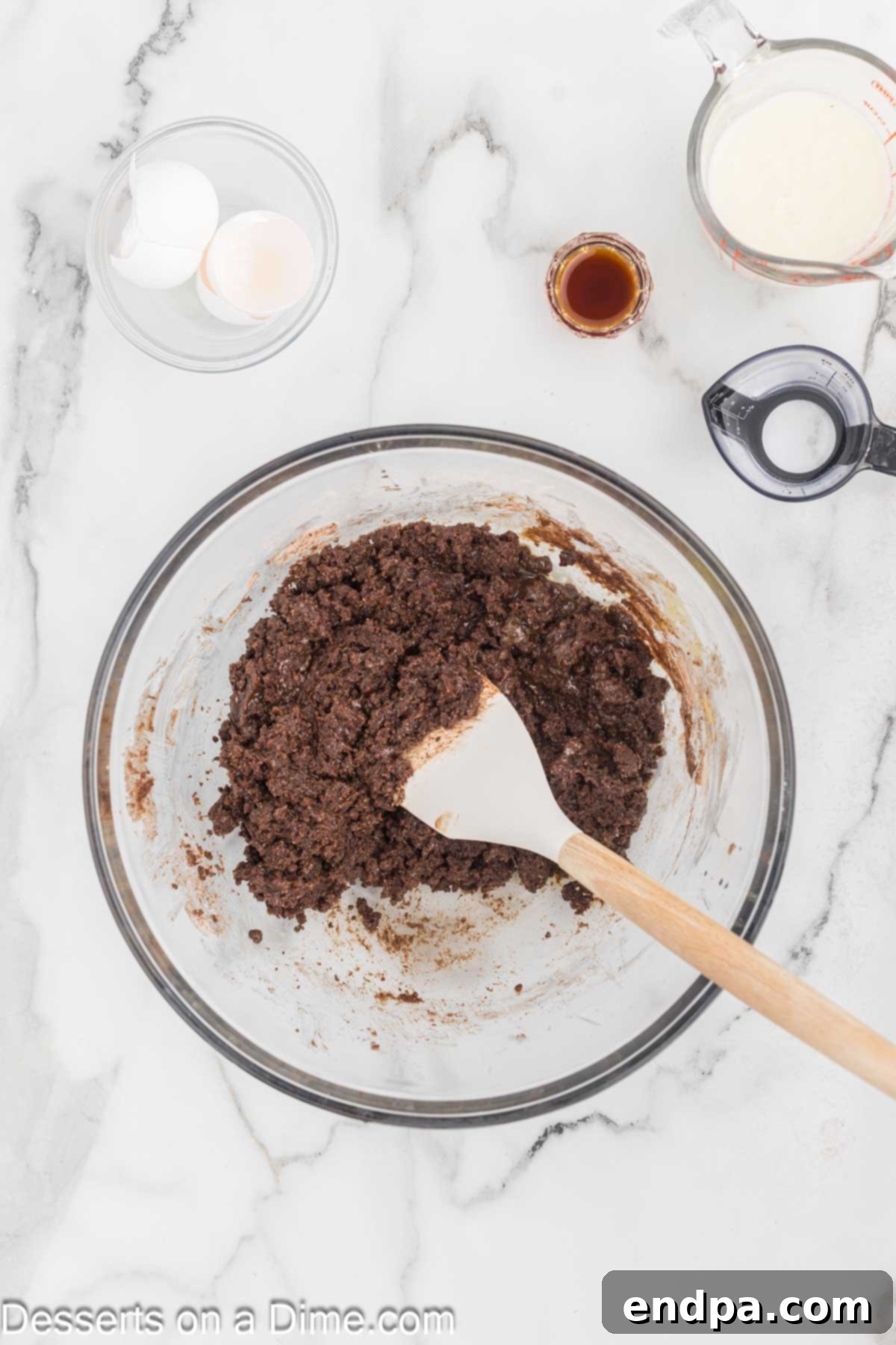 Bite Sized Chocolate Bliss 4 Melted butter and eggs being added to the dry chocolate cake batter ingredients in a mixing bowl.