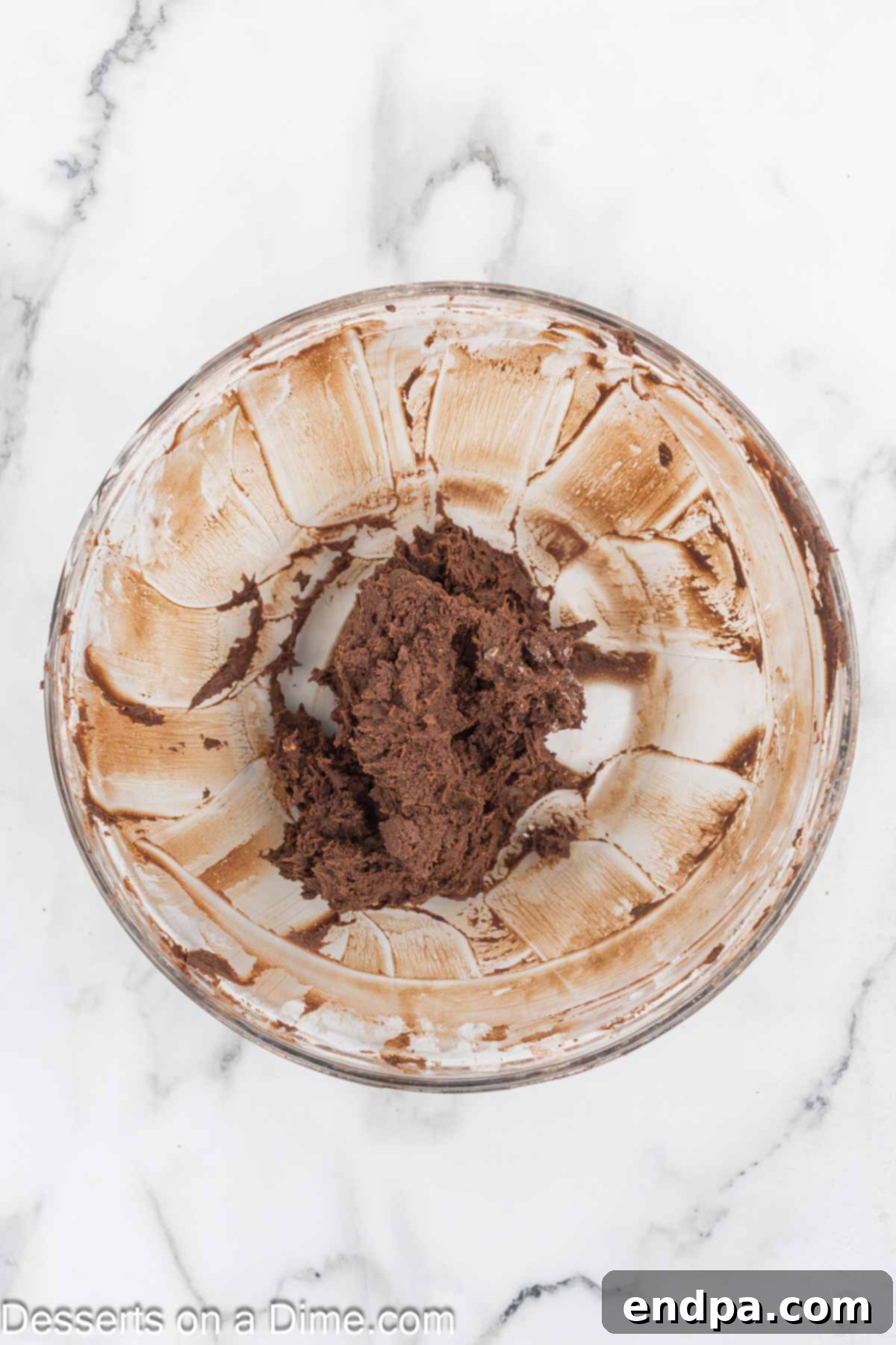 Bite Sized Chocolate Bliss 8 Confectioners' sugar and unsweetened cocoa powder being added to the beaten butter in a mixing bowl.