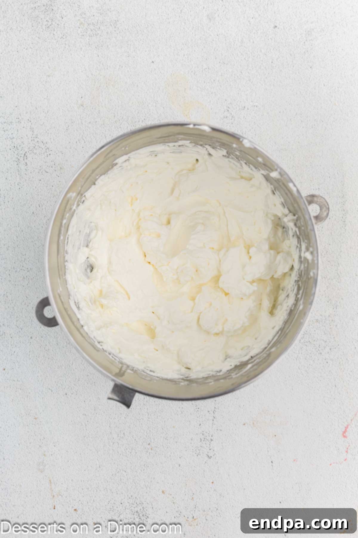 Heavy cream, powdered sugar, and vanilla extract being combined in a chilled mixing bowl.