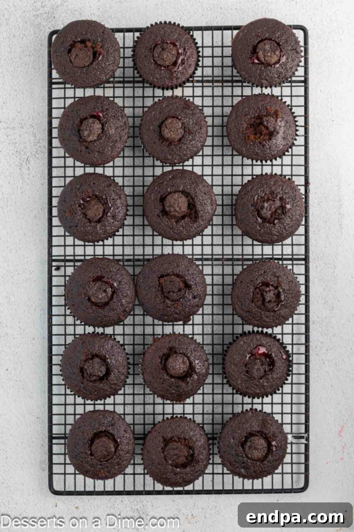 The top of the cored cupcake being placed back over the cherry filling.