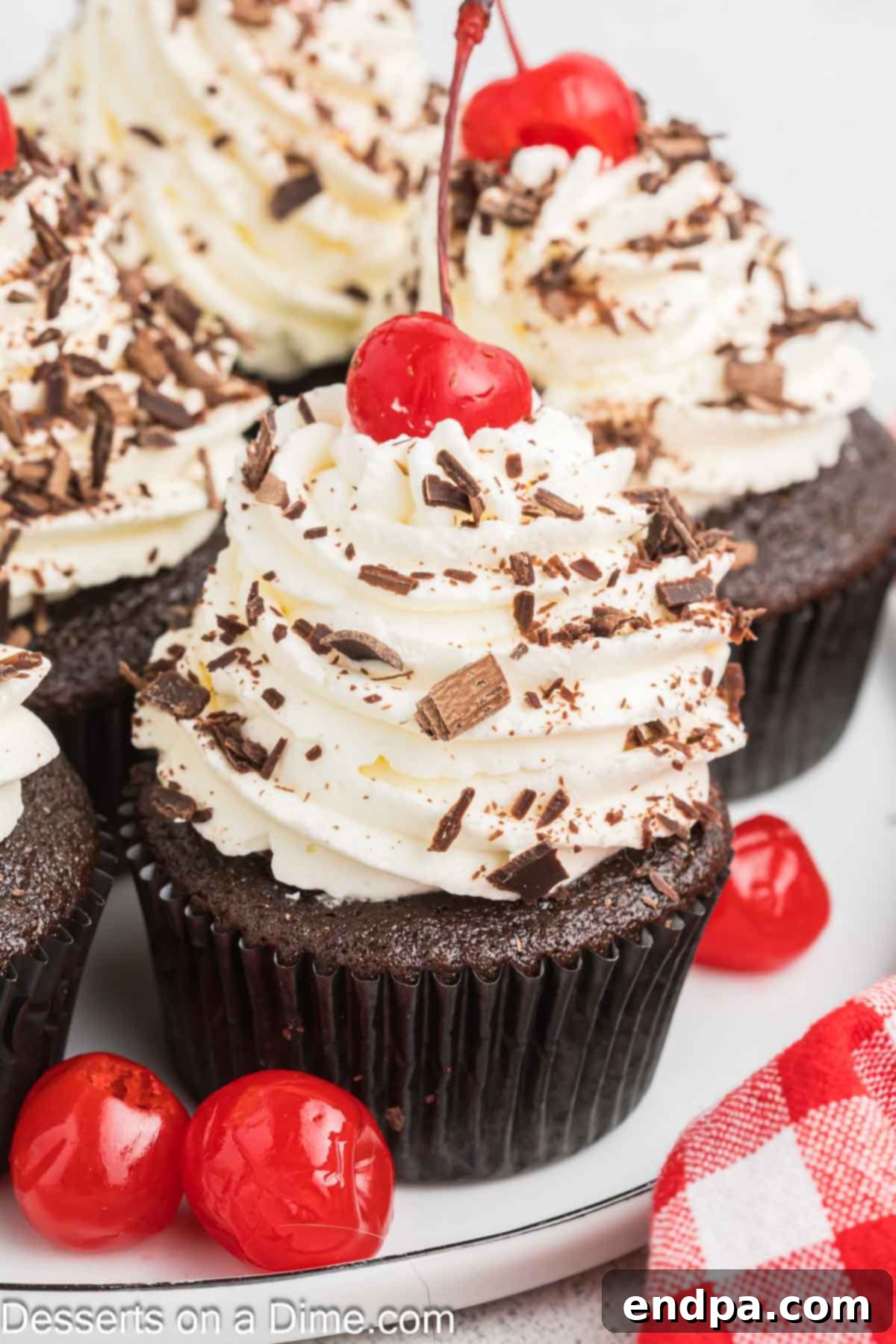 Cupcakes generously topped with whipped cream and chocolate shavings.