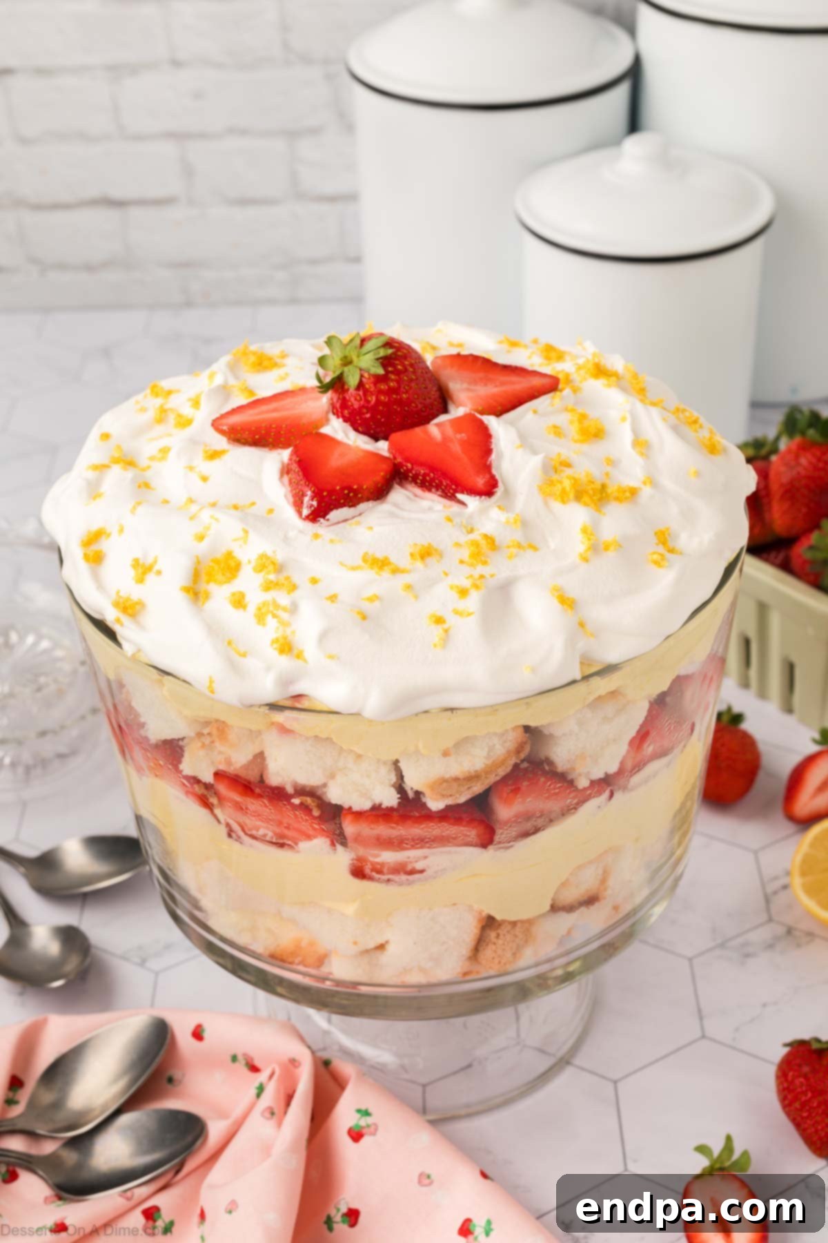 Lemon Strawberry Trifle Dessert assembled and ready to serve, showcasing vibrant layers of yellow pudding, white cake, and red strawberries.