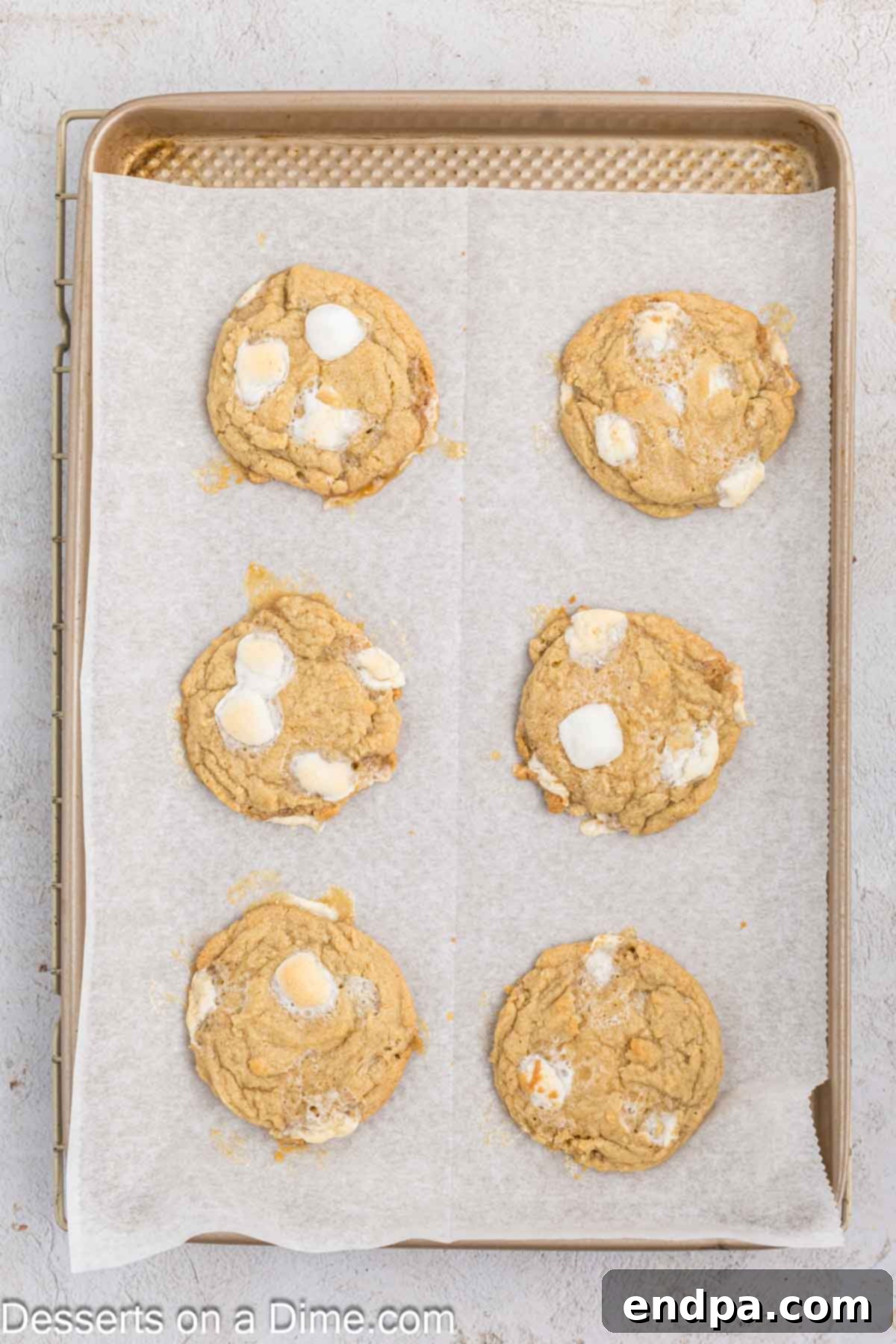 Fluffy Cloud Cookies 9 Freshly baked Marshmallow Cookies cooling on a baking sheet, with golden edges and toasted marshmallow tops.