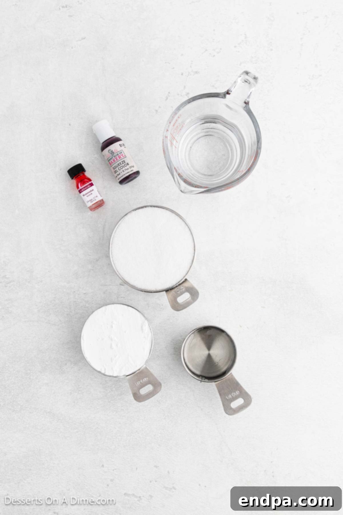 Ingredients for homemade hard candy, including granulated sugar, corn syrup, a small bottle of flavoring oil, a bowl of powdered sugar, and food coloring.