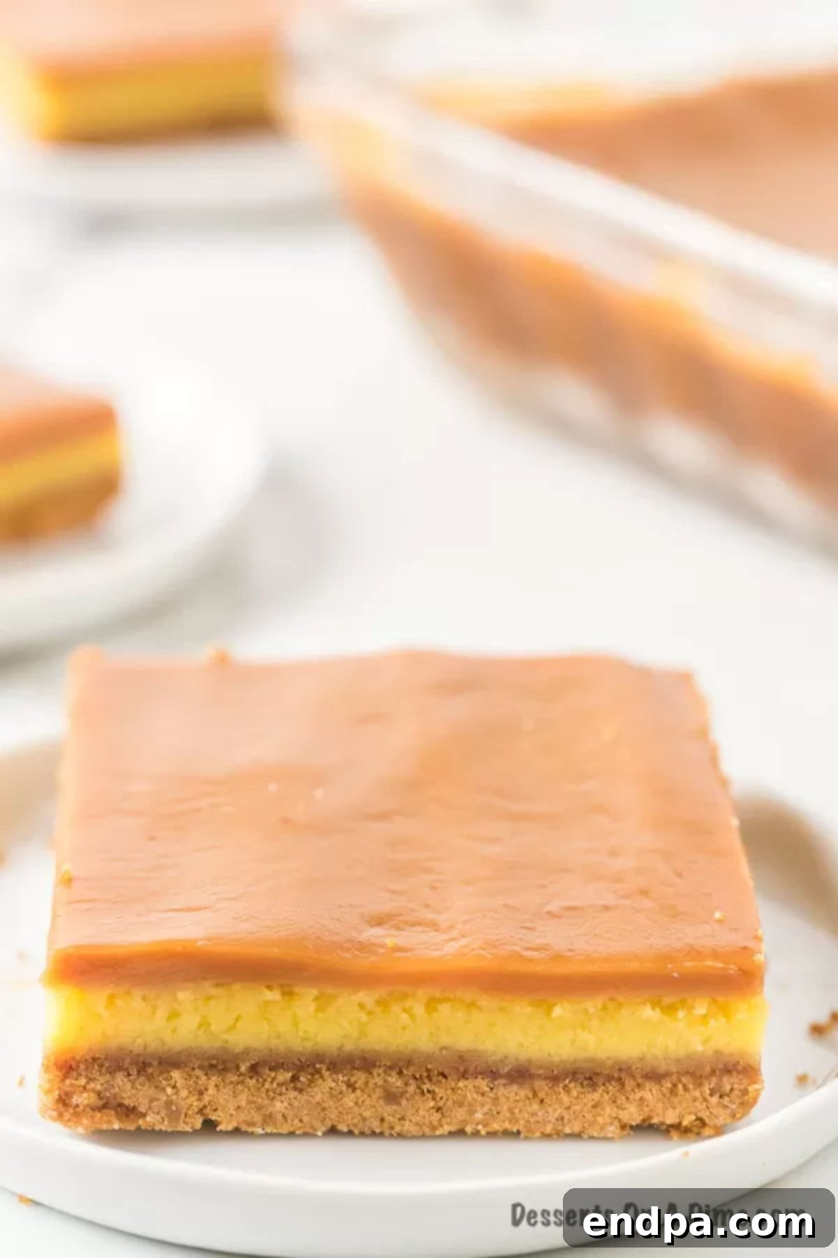 Caramel cheesecake bar cut and served on a plate. 