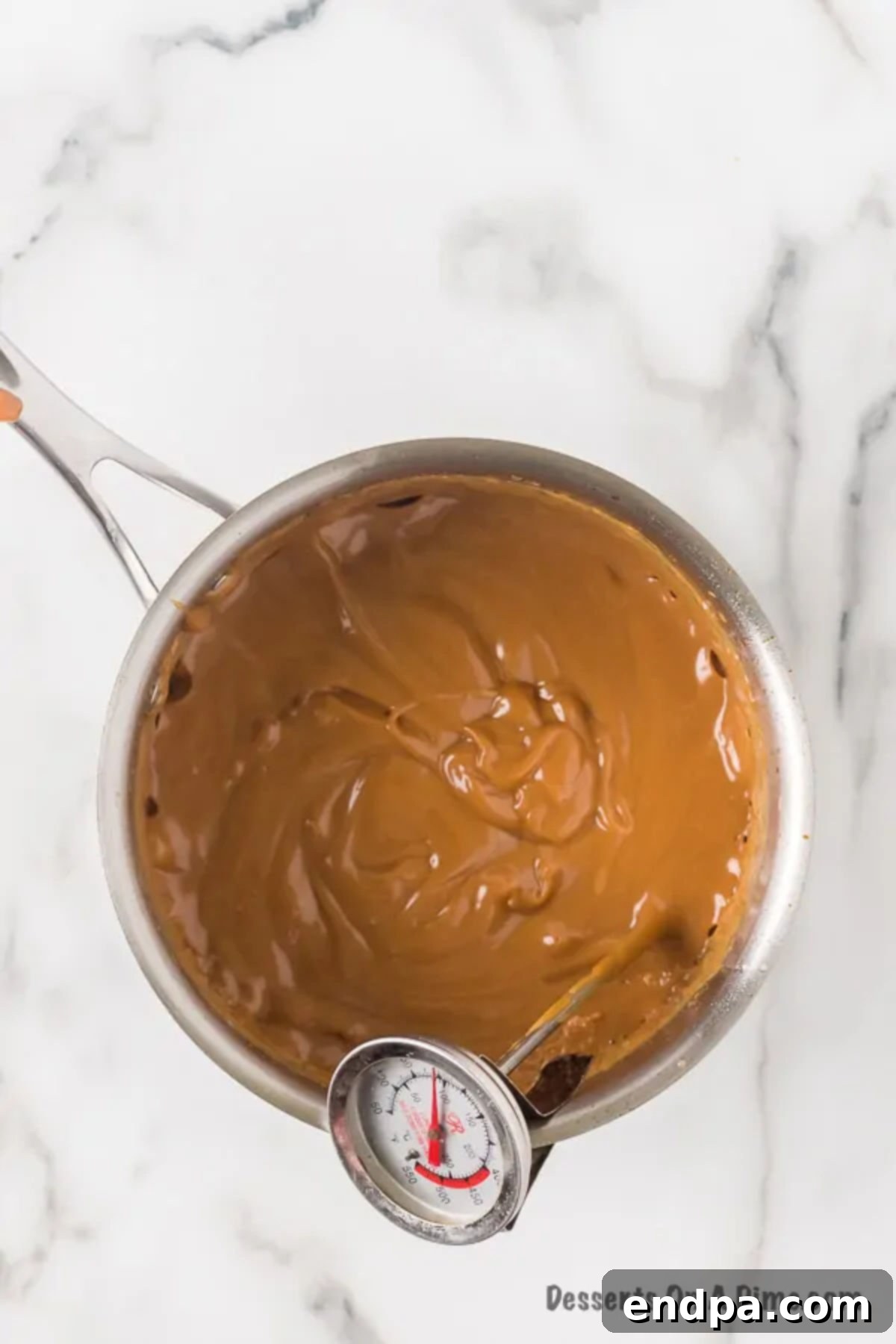 Sauce pan of caramel and a candy thermometer. 